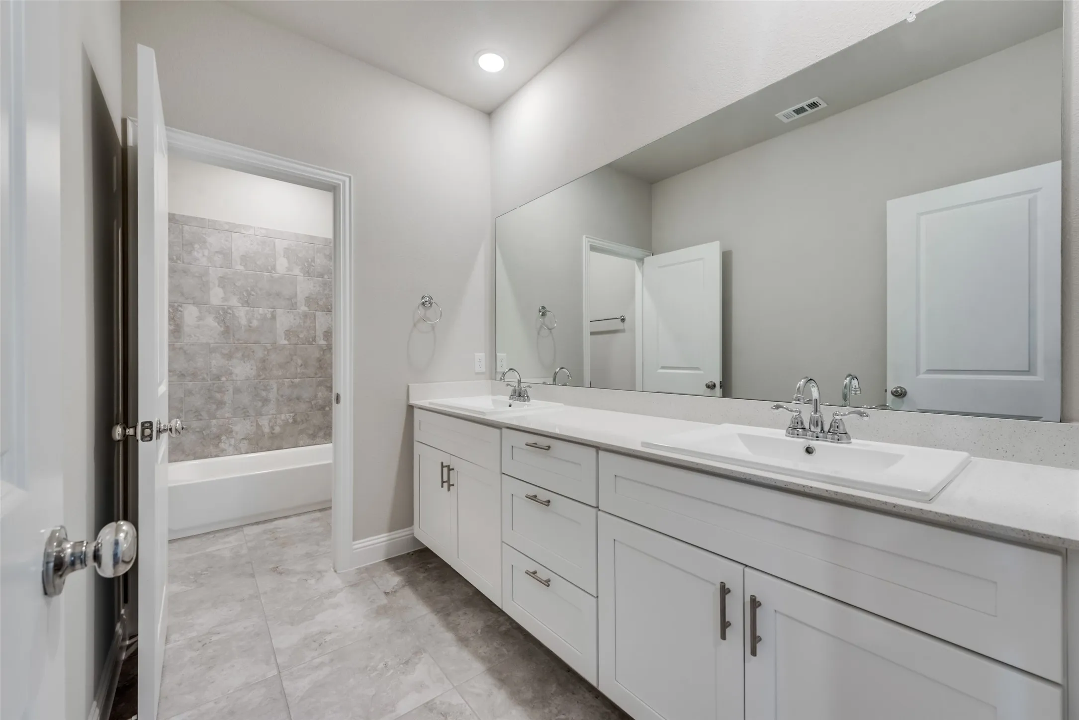 Double vanity with white cabinetry and integrated sinks set in a light-colored countertop