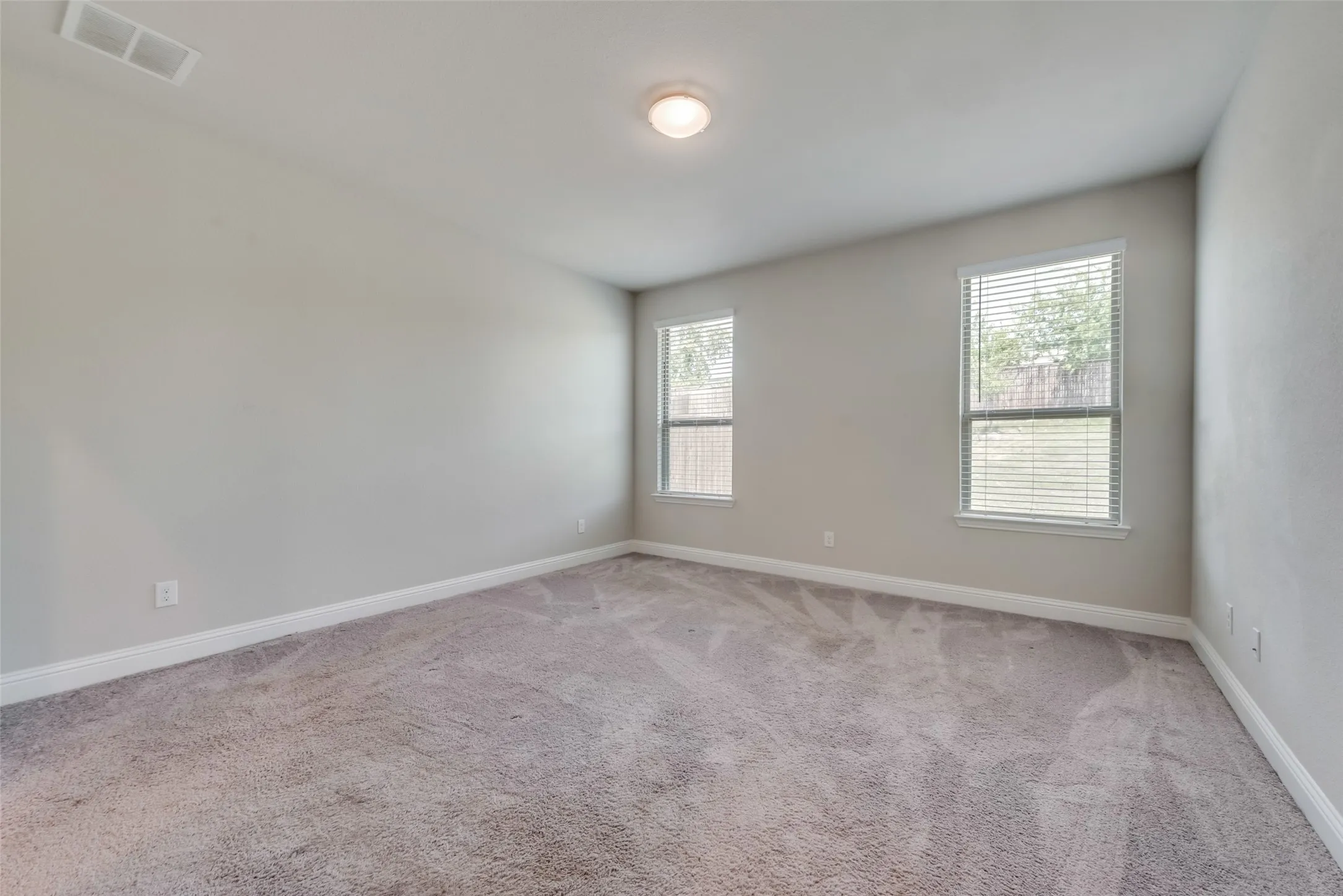 Carpeted room with neutral wall paint and white trim