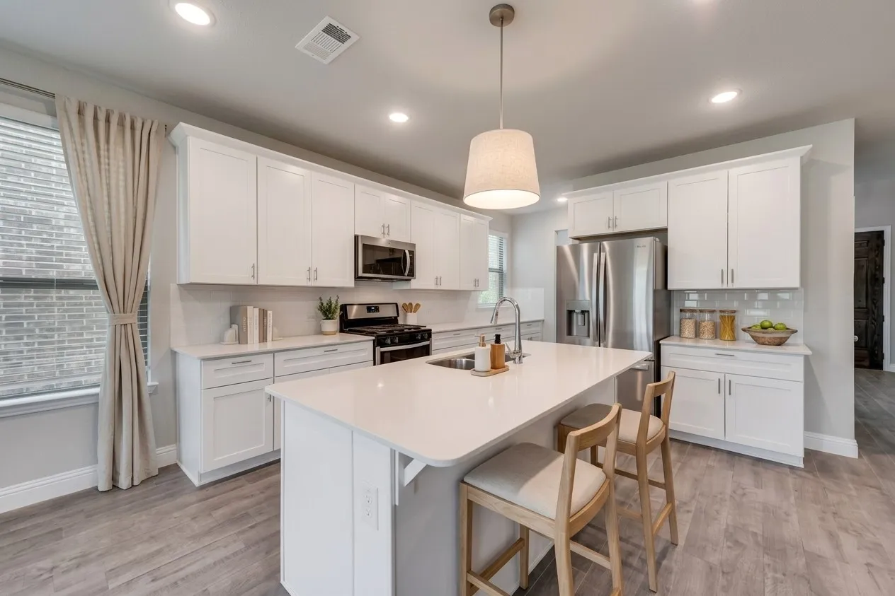 Spacious kitchen featuring white cabinetry, a large center island, stainless steel appliances, a tile backsplash, and wood-finish flooring