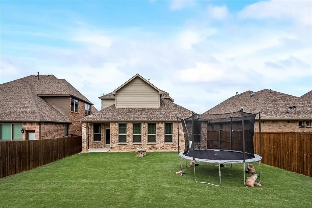 Spacious backyard featuring a sloped, manicured lawn and a privacy​​‌​​​​‌​​‌‌​‌‌​​​‌‌​‌​‌​‌​​​‌​​ fence
