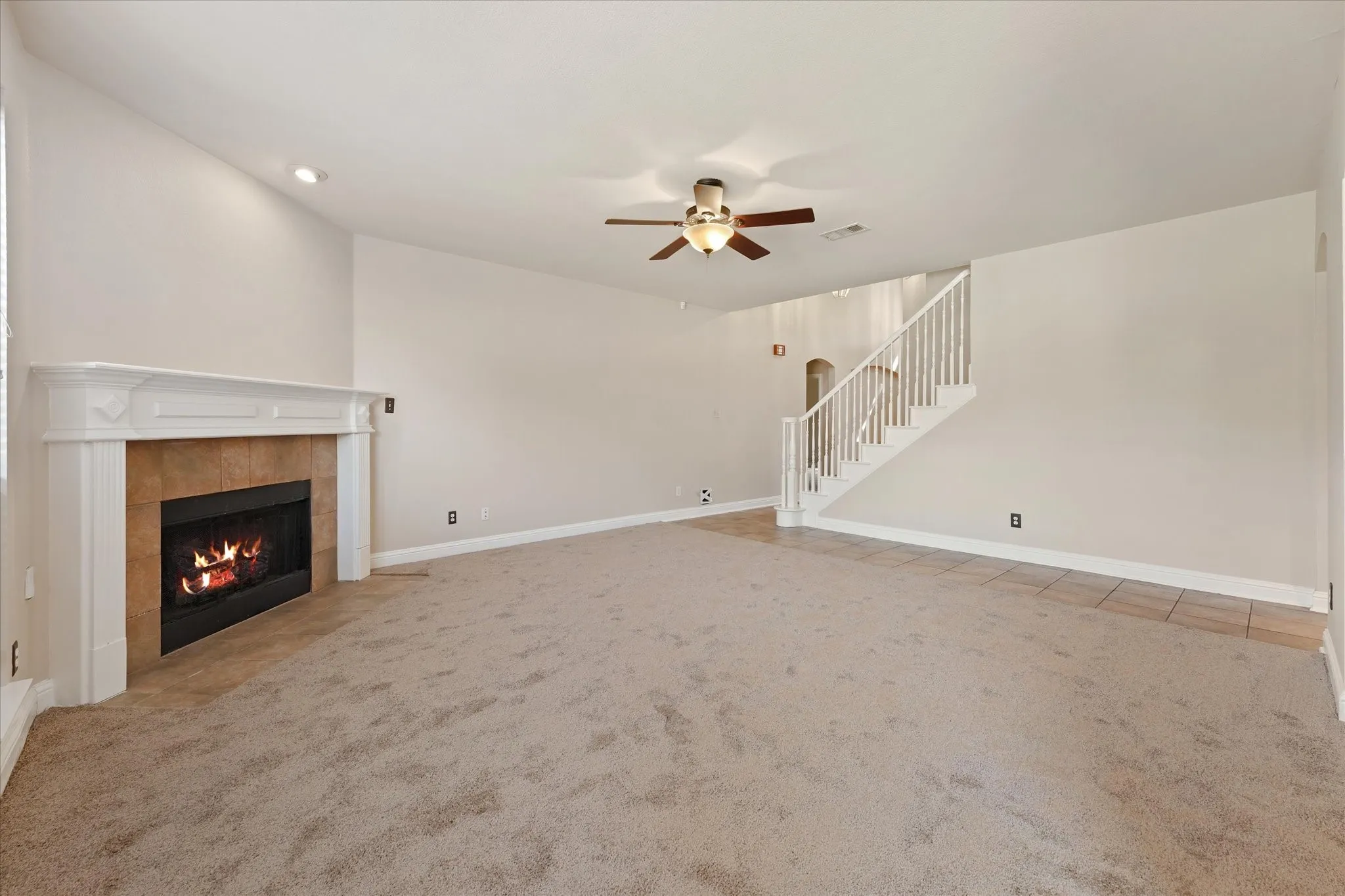 Living area featuring a fireplace with a white mantel, recessed lighting, and a ceiling fan