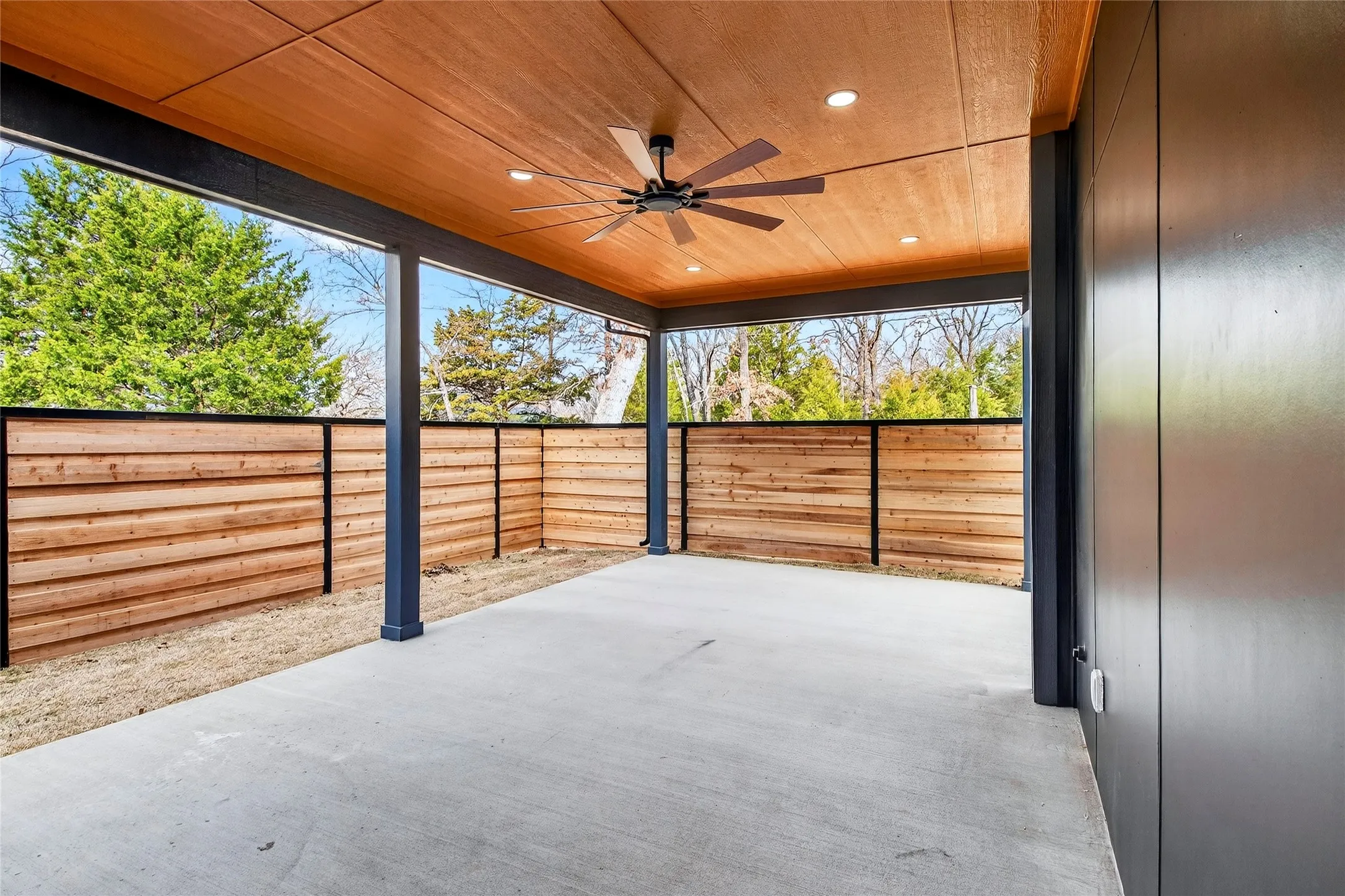 Fenced backyard featuring a ceiling fan and a patio