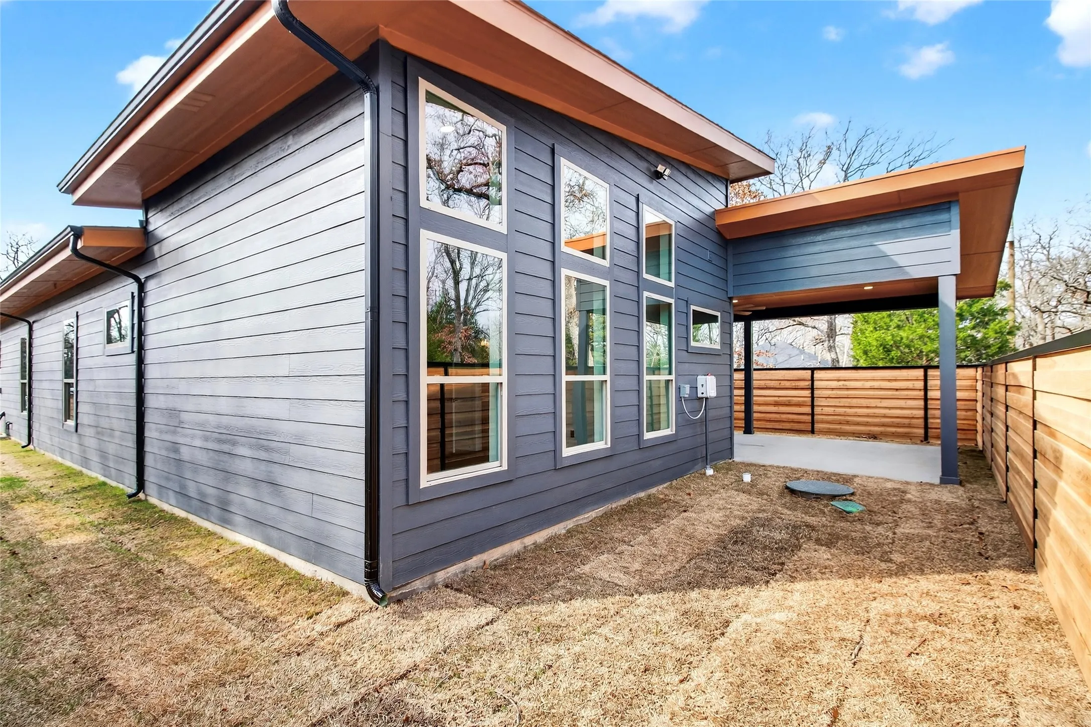 View of side of property with a fenced backyard and a patio