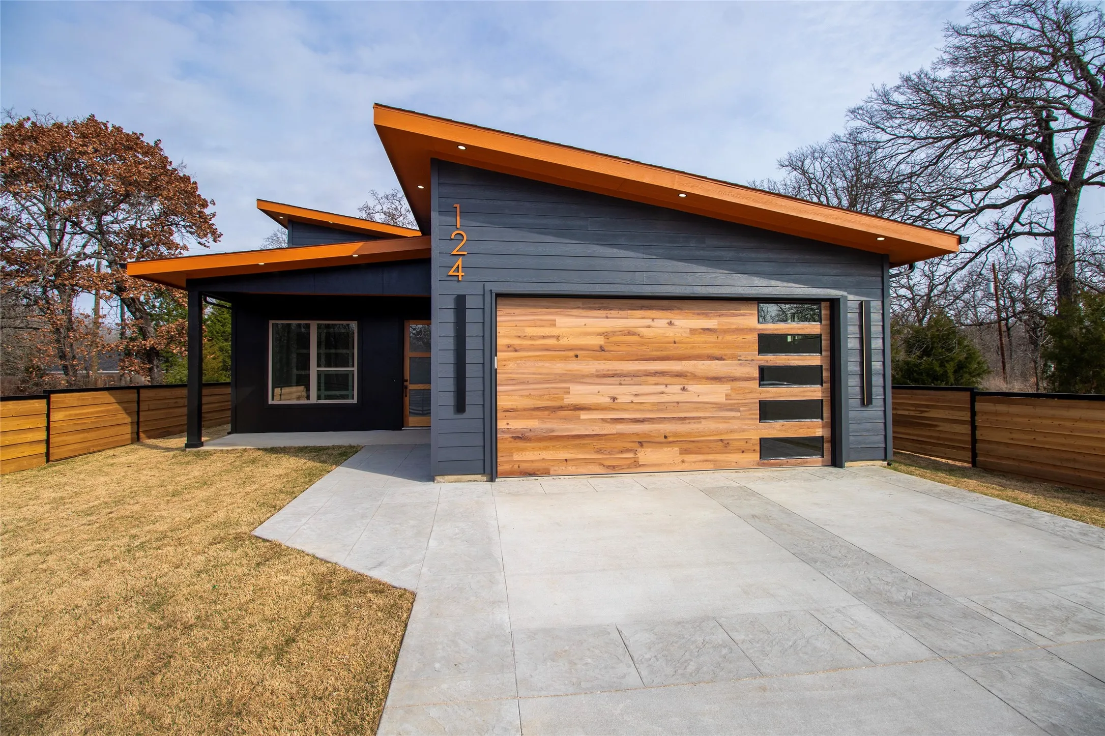 Modern home featuring driveway, a garage, and a patio area
