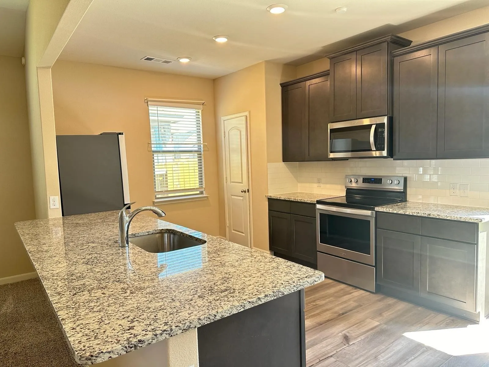 Kitchen island with a stainless steel undermount sink and chrome faucet