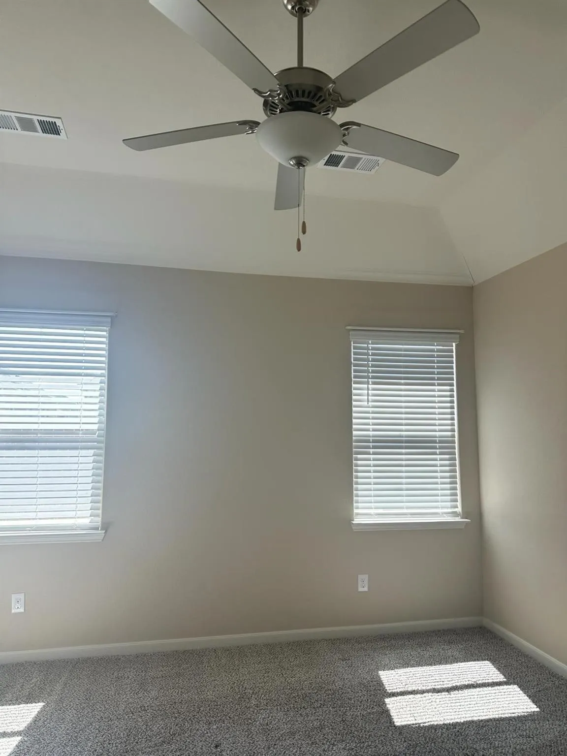 Tray ceiling featuring a brushed nickel ceiling fan with integrated lighting