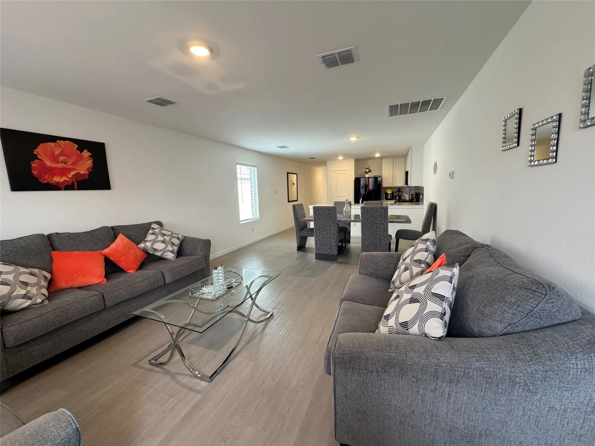 Open-concept living area with wood-finish flooring, recessed lighting, and white walls