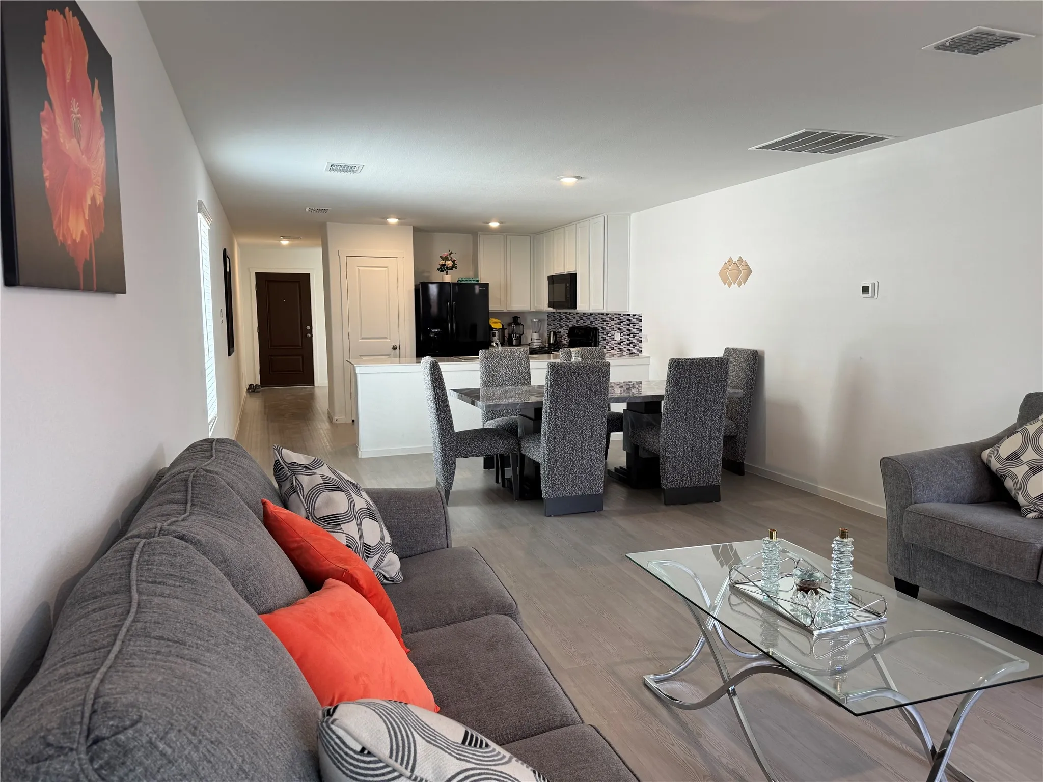 Open-concept living area with wood-finish flooring extending into the dining space