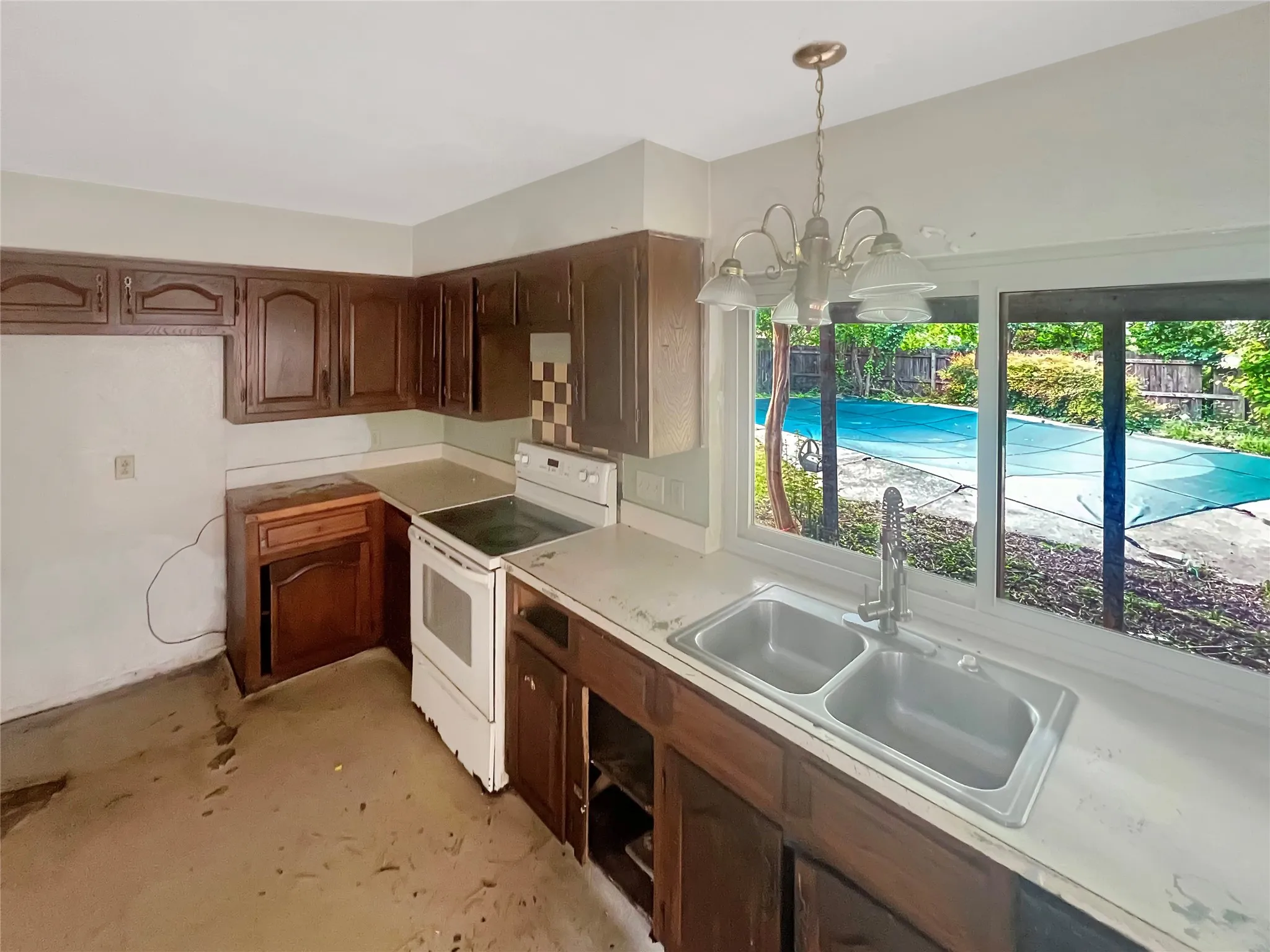 Kitchen featuring a dual basin sink, white countertop, and dark wood cabinetry