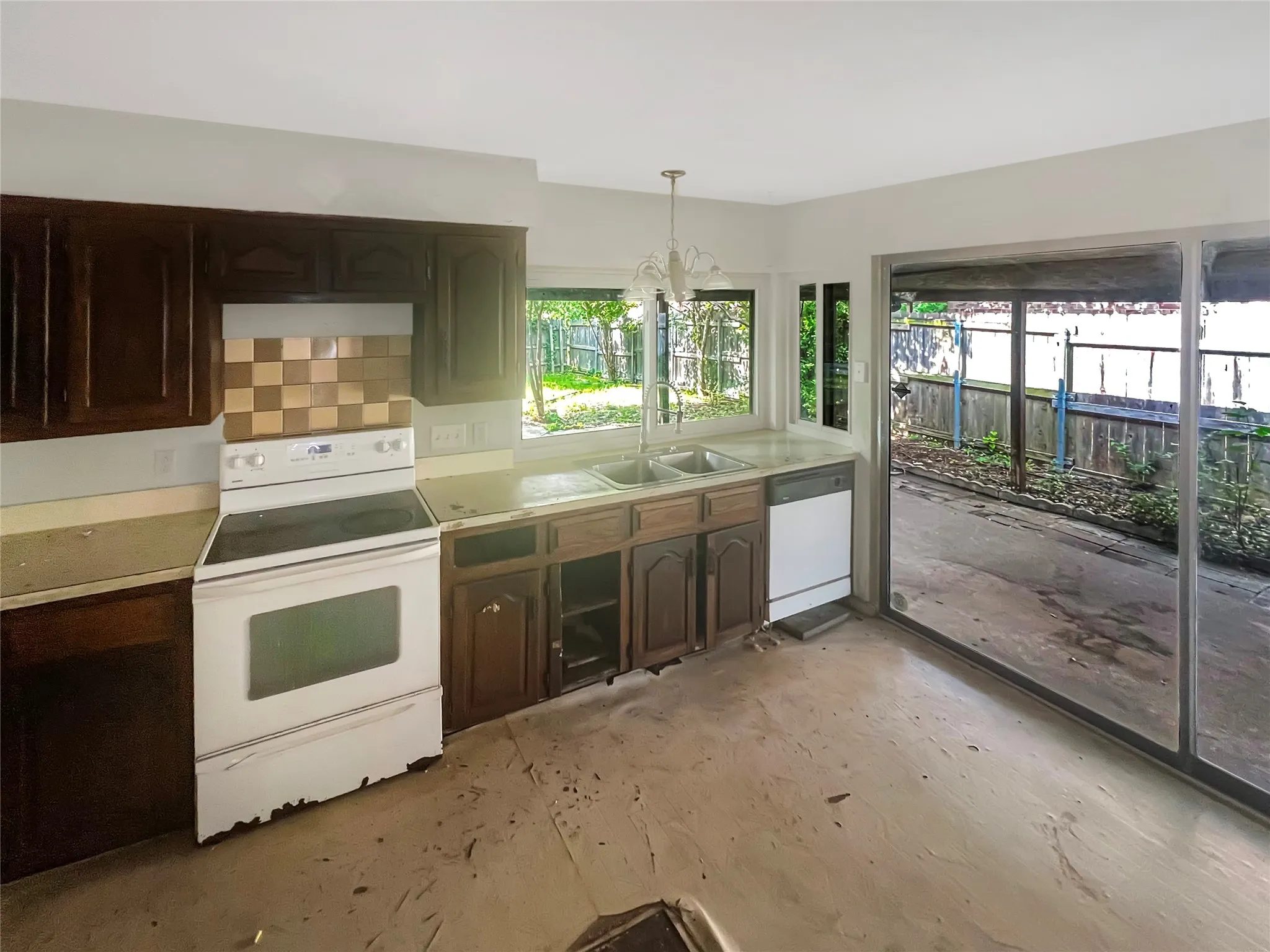 Kitchen featuring wood-finish cabinetry, a white electric range, and a white built-in dishwasher