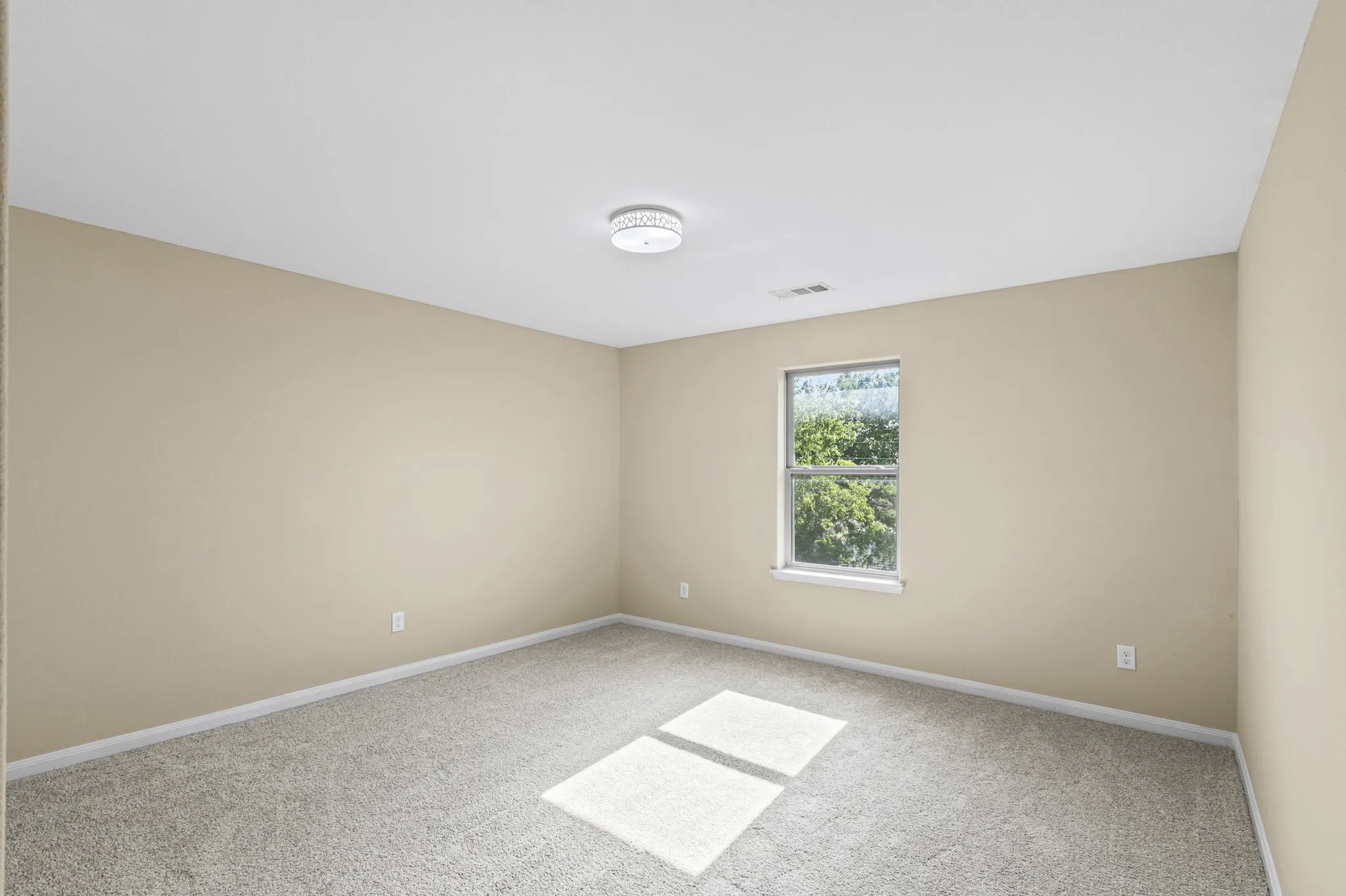 Interior room featuring beige walls, light gray carpet, and a flush mount ceiling light