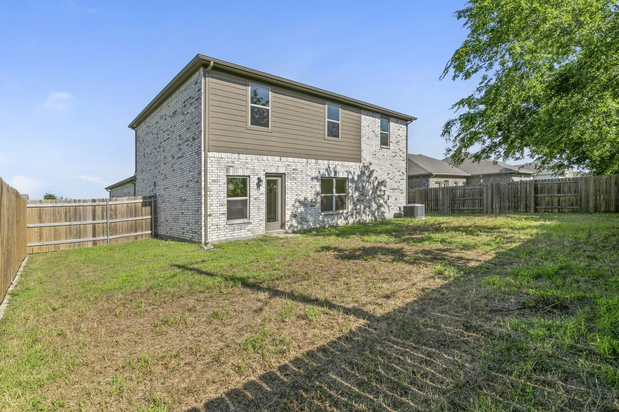Two-story exterior featuring light brick and horizontal siding