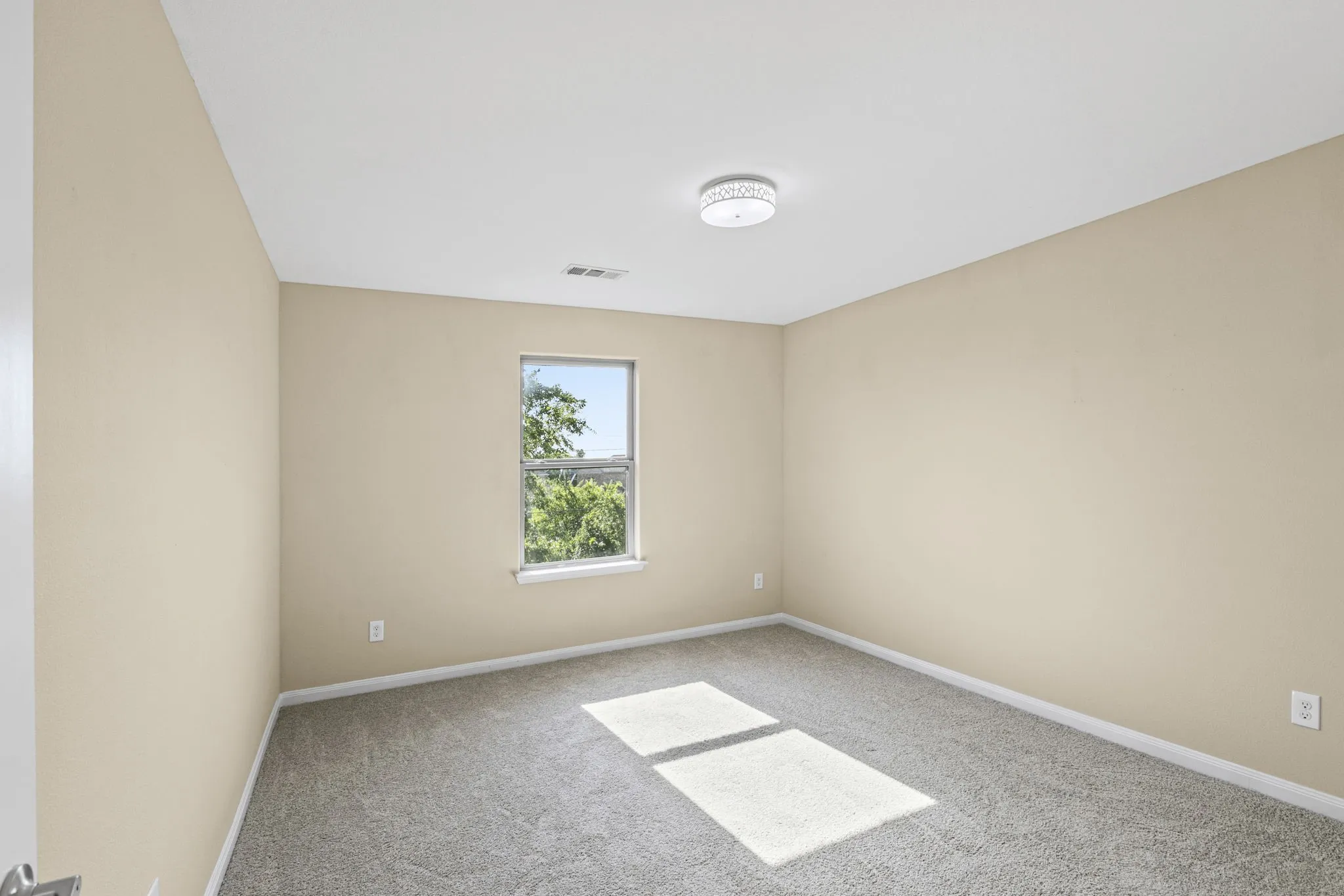 Bedroom featuring neutral wall paint, gray carpet flooring, a single window, white trim, and a flush-mount ceiling light fixture