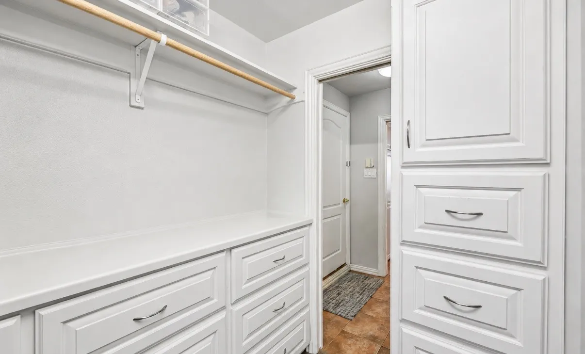 This picture show only half of the nice-sized walk-in primary closet with excellent build-ins