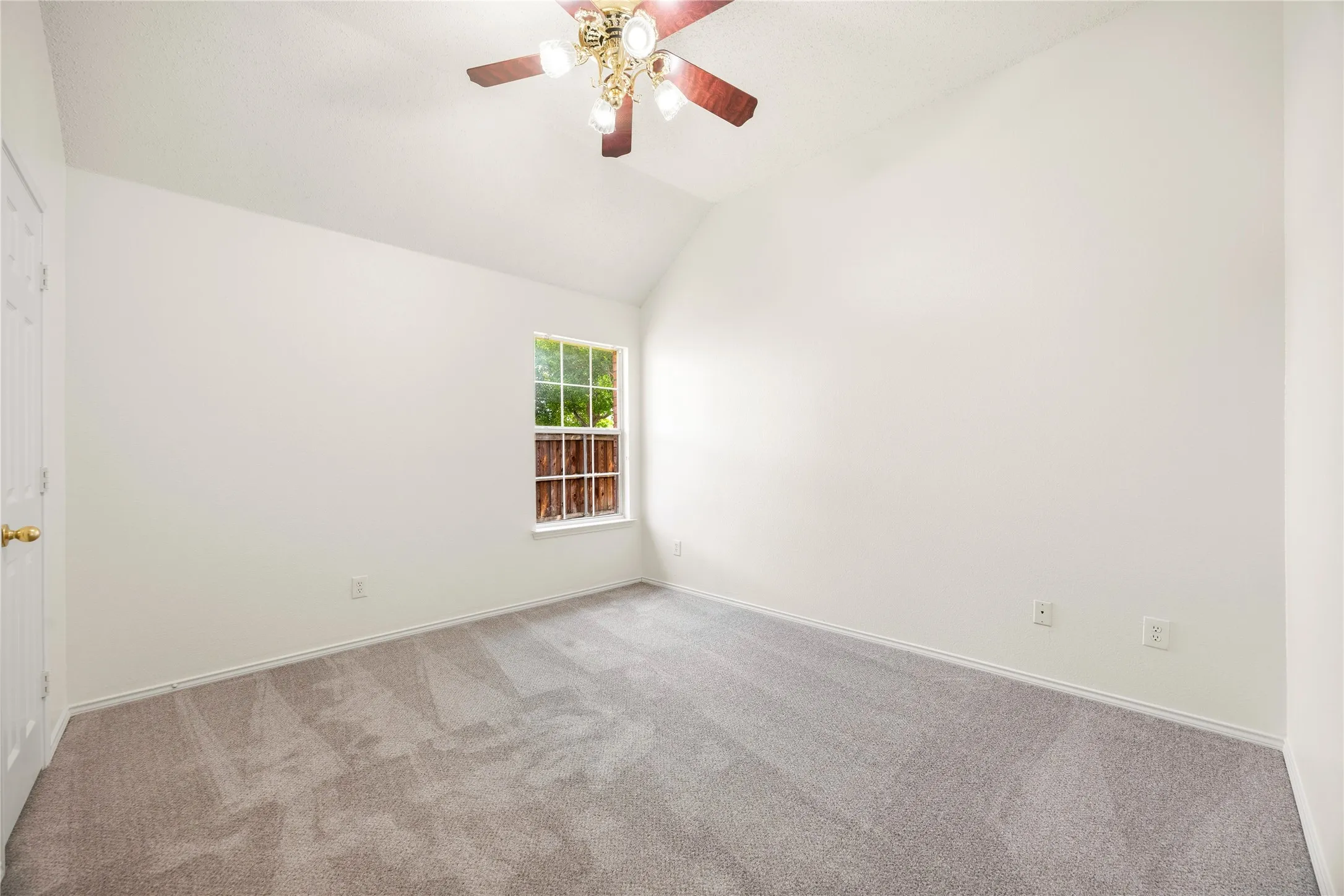 Vaulted ceilings feature a ceiling fan with integrated lighting