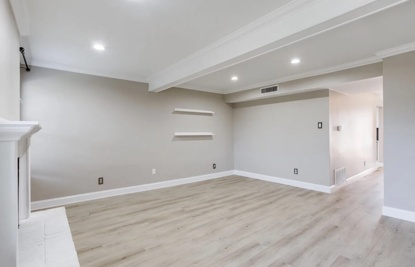 View as you enter your new home. Fireplace and window on your left, hallway to the kitchen, dining room, half bath, private courtyard, and double car garage.