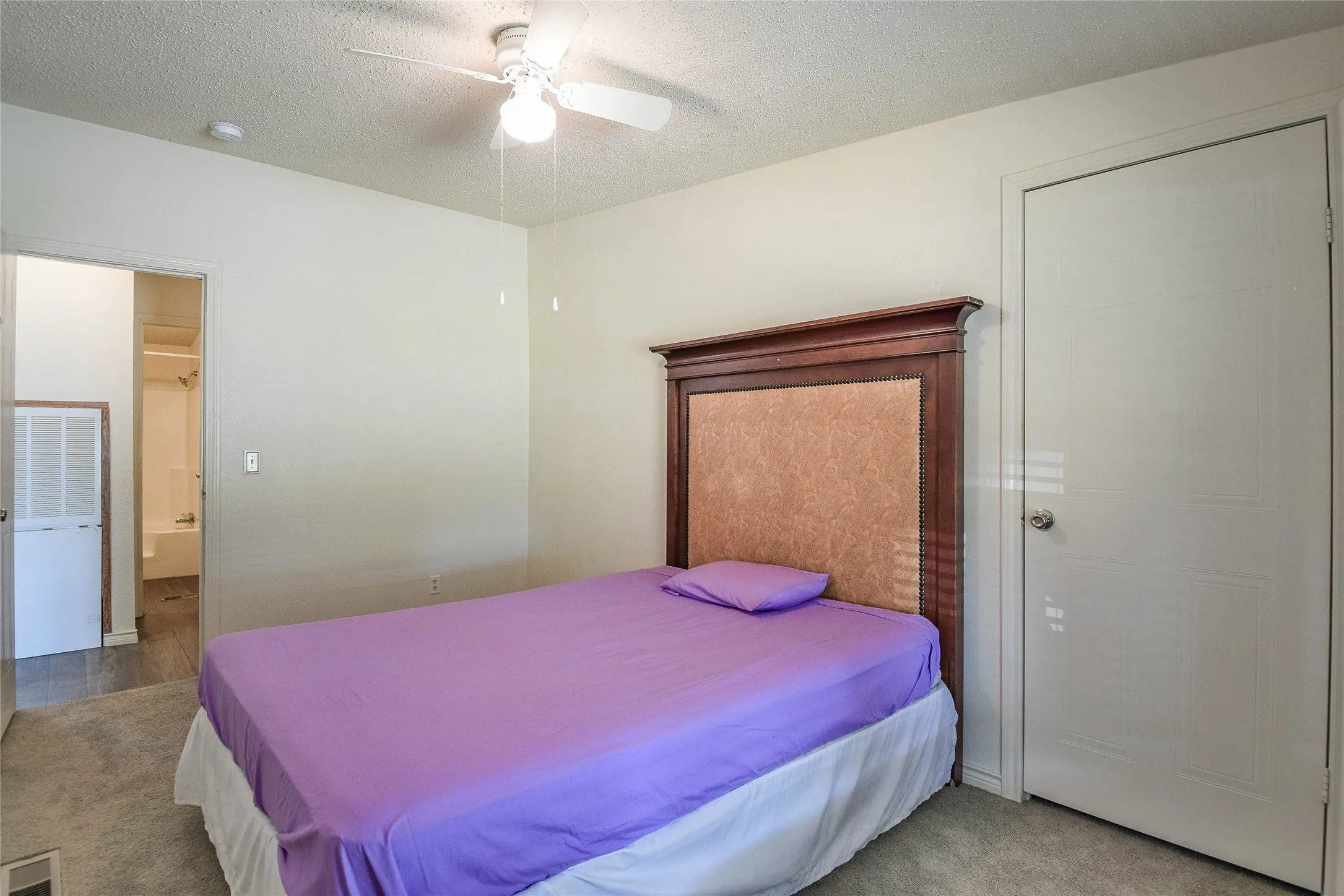 Great guest bedroom with carpet and ceiling fan.