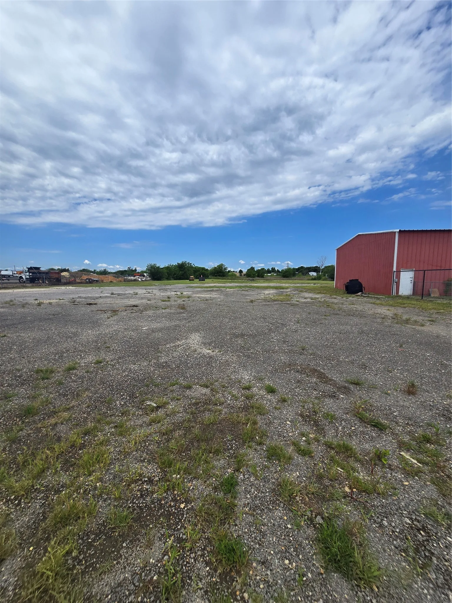 Expansive gravel lot with interspersed grass