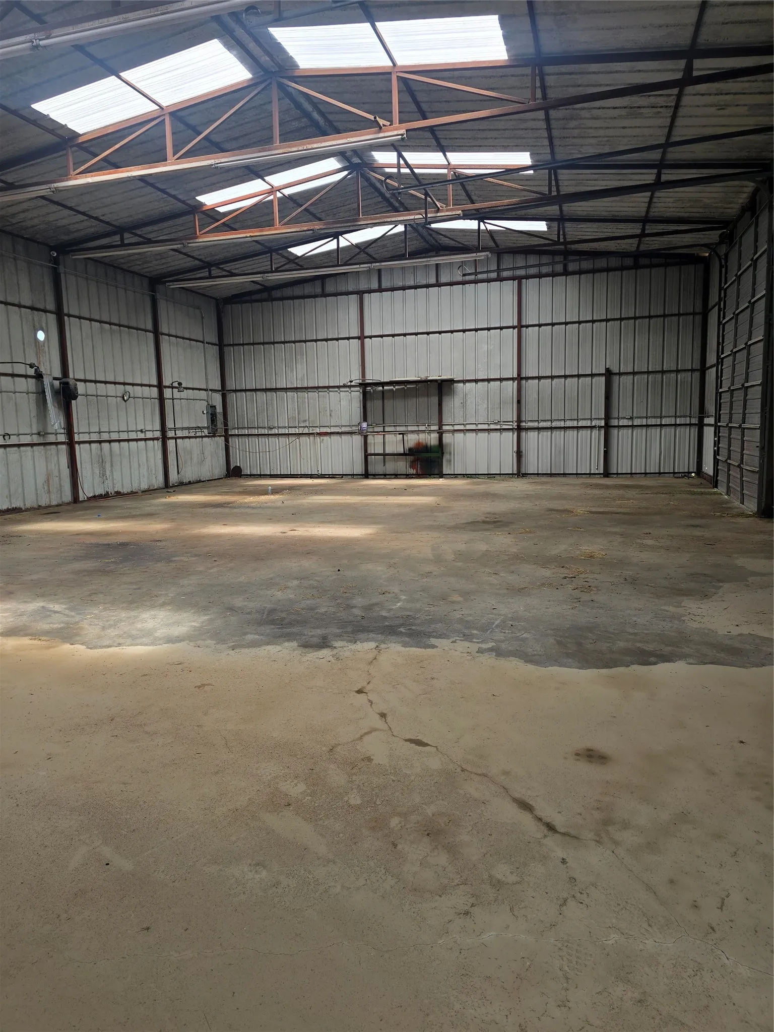 Spacious warehouse interior featuring metal corrugated walls and a concrete floor