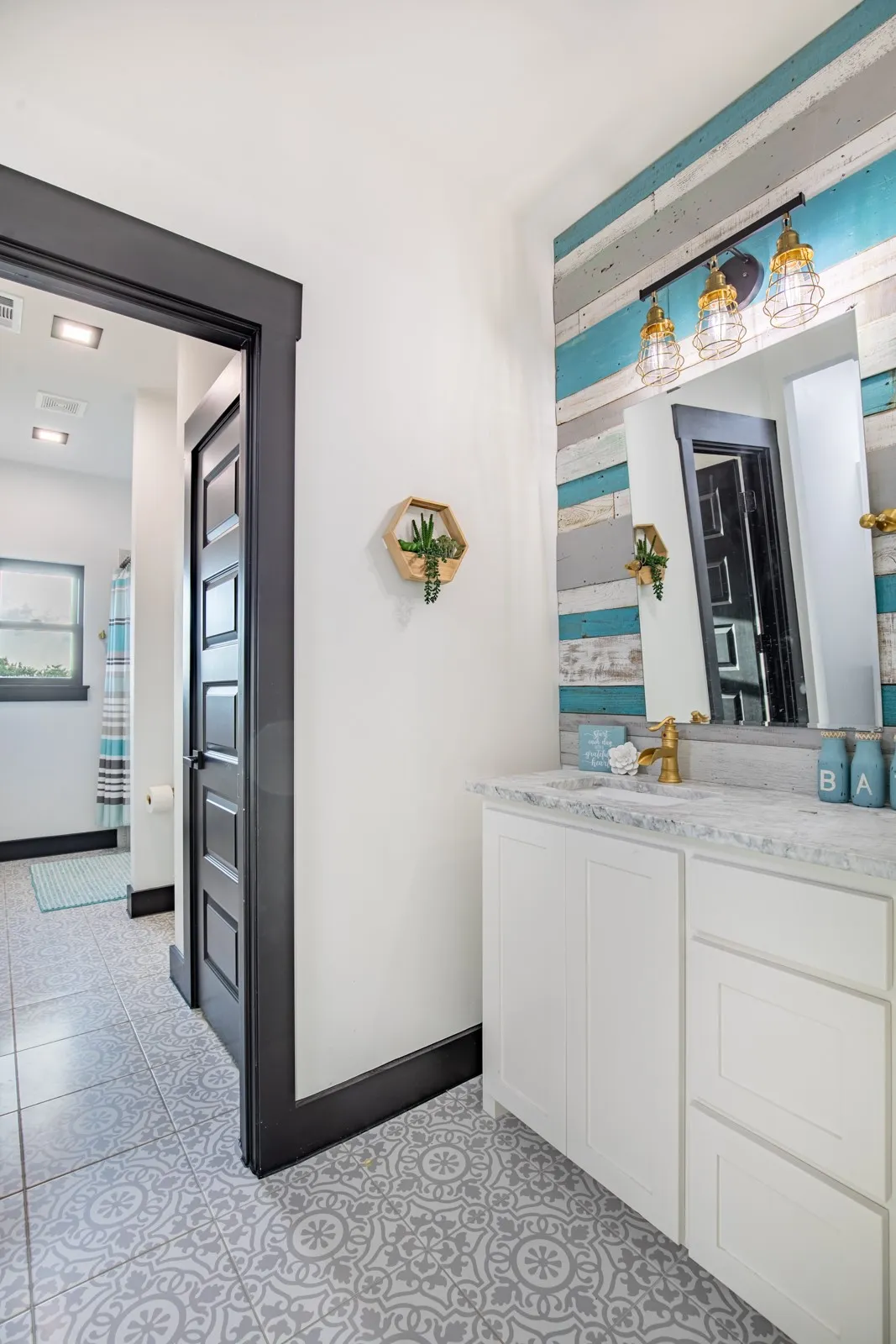 Jack and Jill bathroom with charming tile, white cabinets and spacious walk-in closets