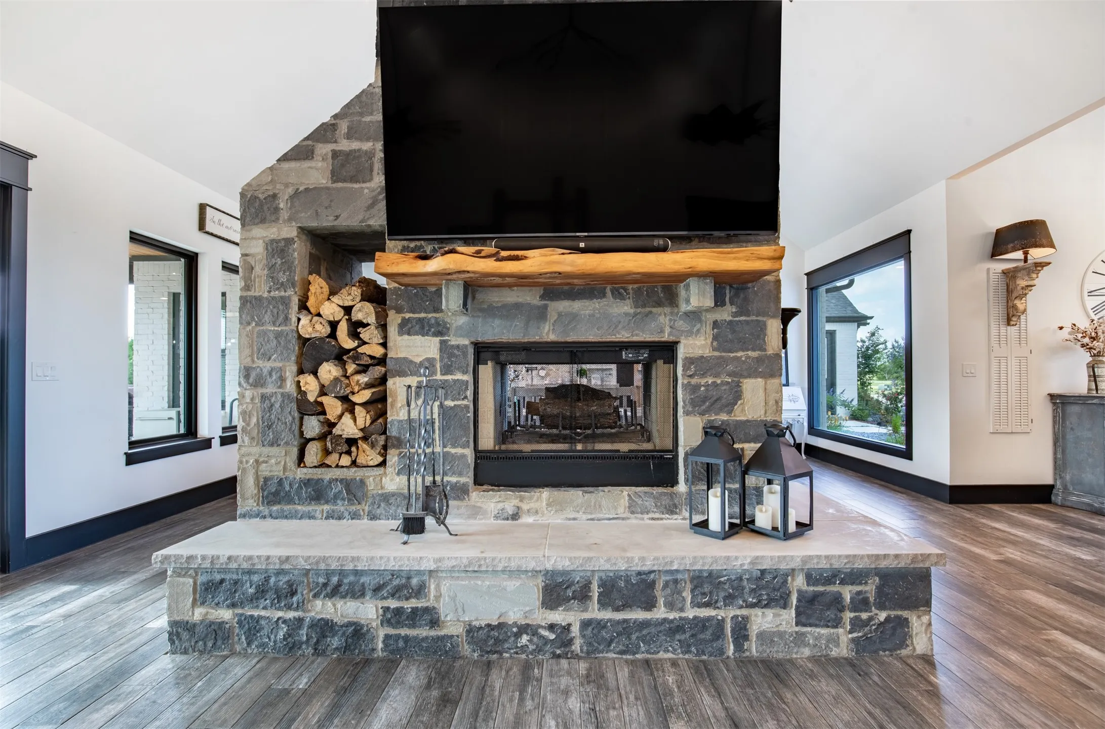 Stunning custom styled double wood burning fireplace opens to living and dining areas