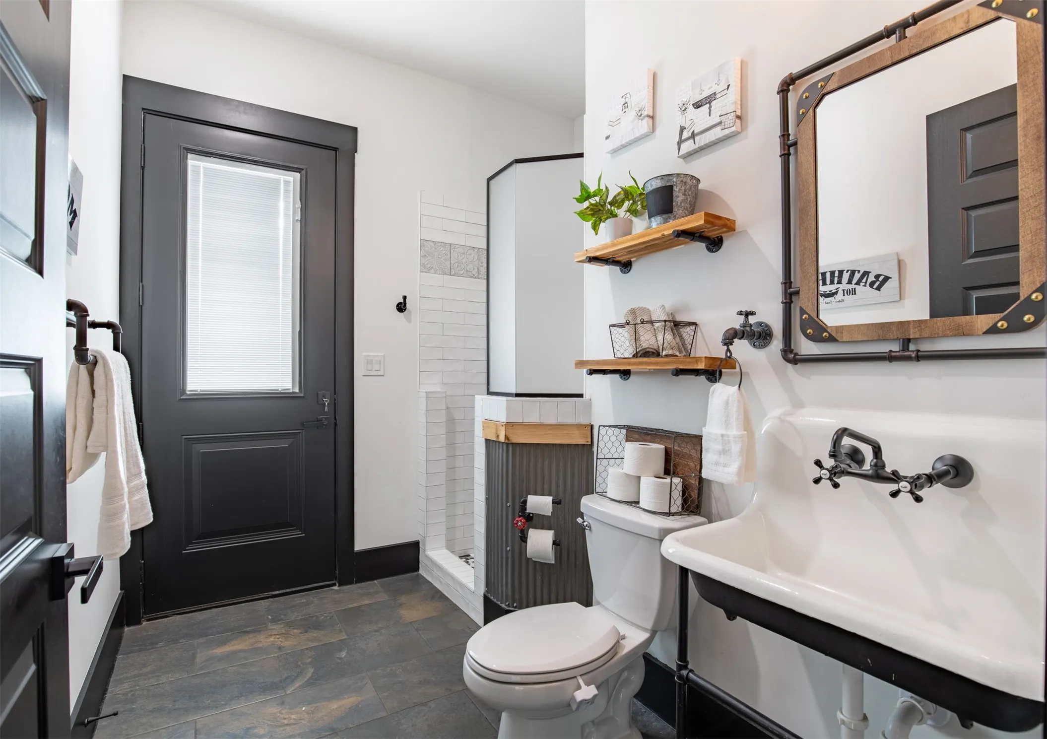 Downstairs pool bath with reclaimed metal sink and full shower. Private door leading to backyard.