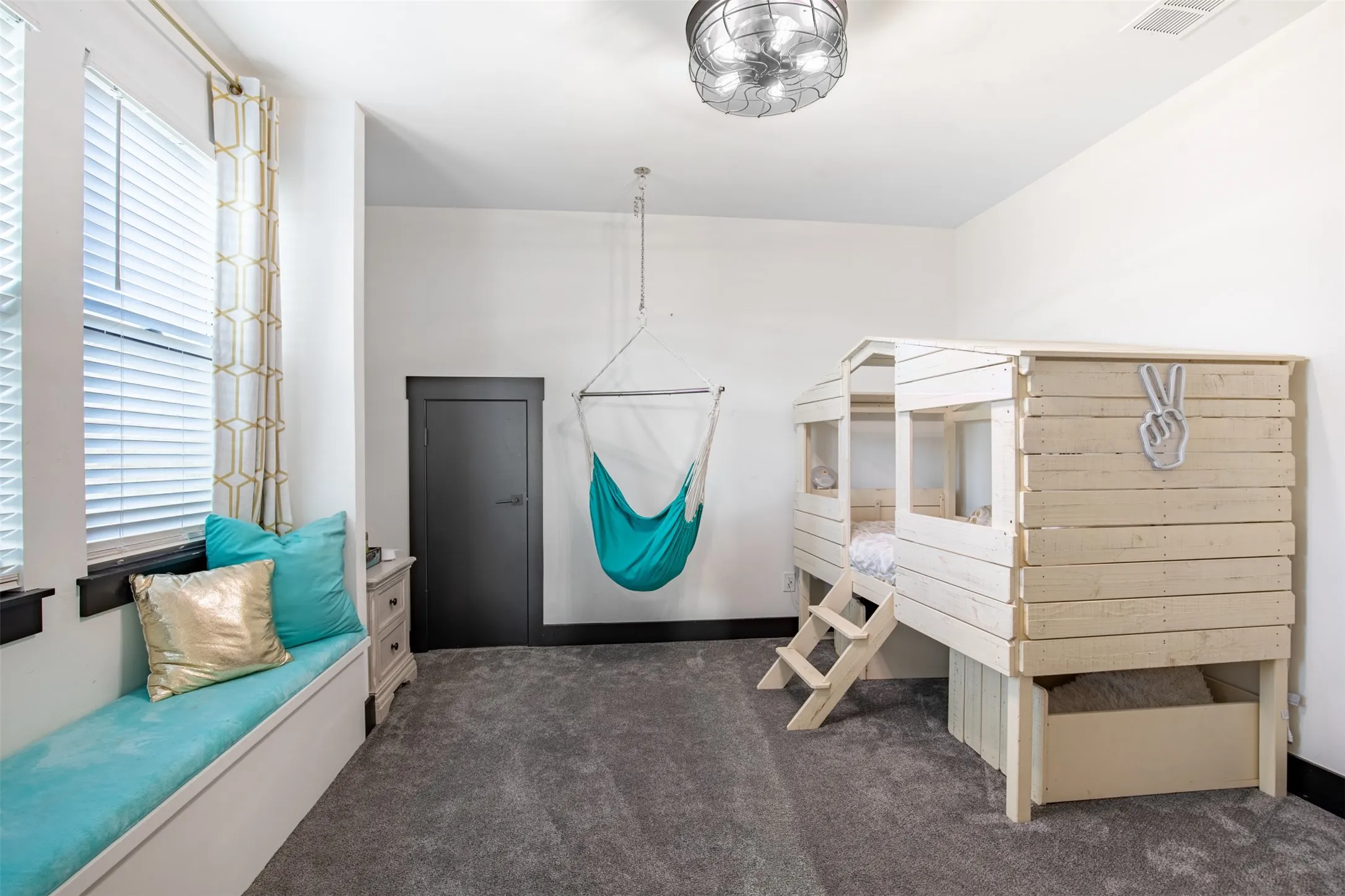 Upstairs secondary bedroom with built-in bench and fan with integrated light