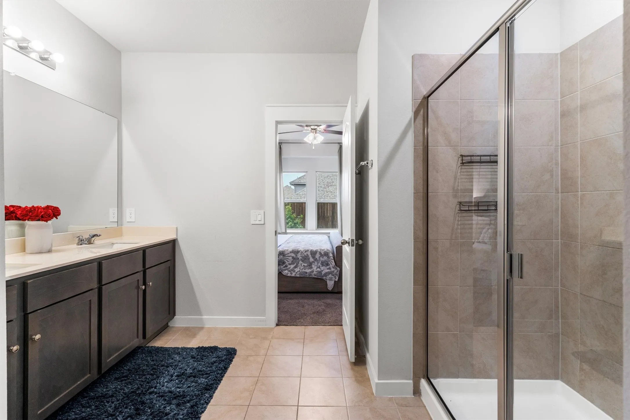 Bathroom featuring a double vanity with dark wood-finish cabinetry and light countertops
