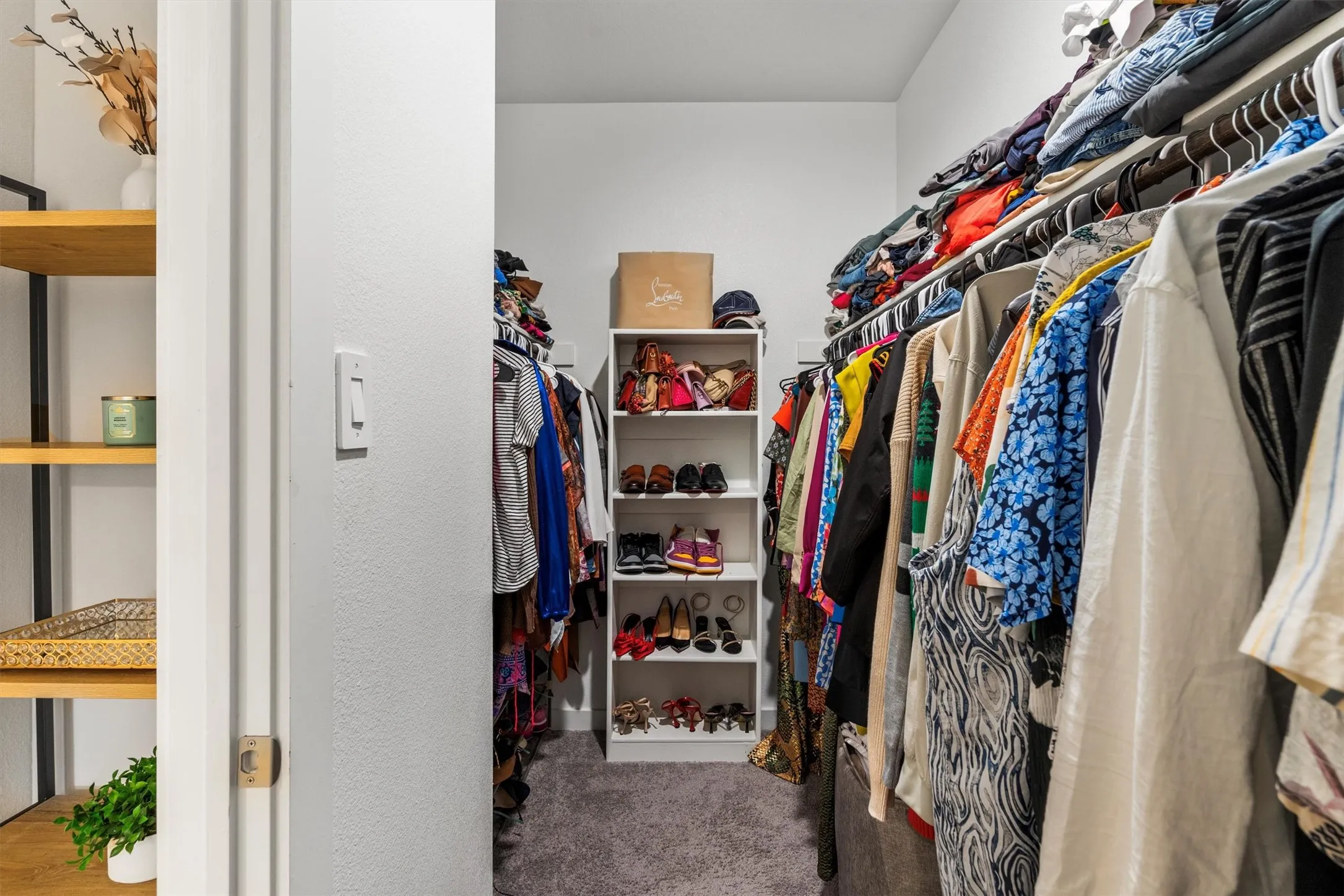 Walk-in closet featuring carpet flooring, built-in shelving, and hanging rods