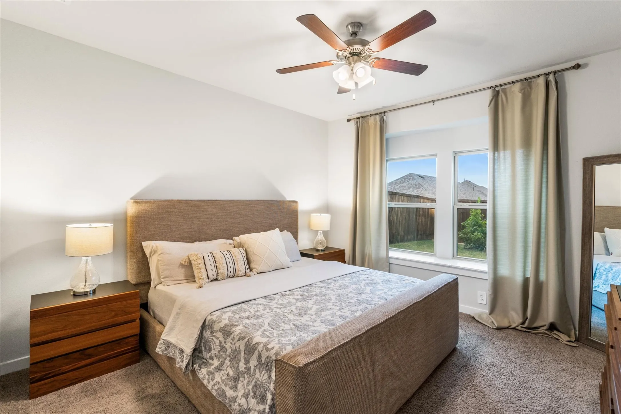 Recessed window with exterior views, accompanied by a wood-finish ceiling fan with integrated lighting
