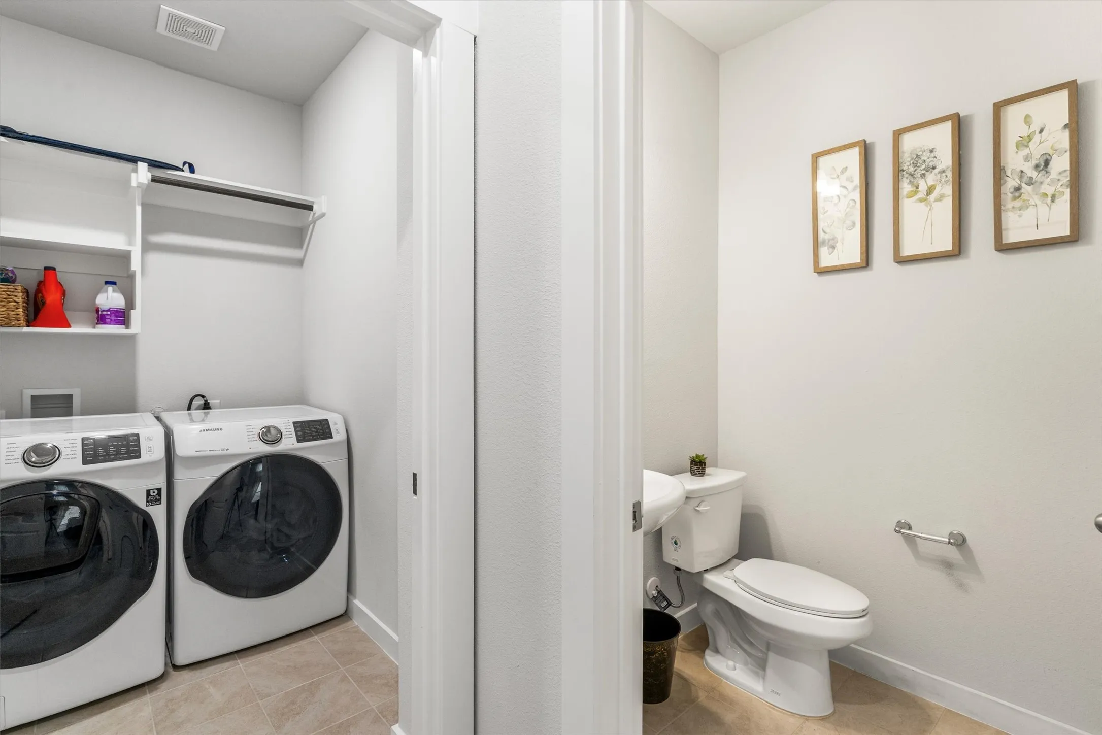 Dedicated laundry area with white shelving and hanging rod, complemented by a nearby lavatory featuring a white toilet and light-toned wall