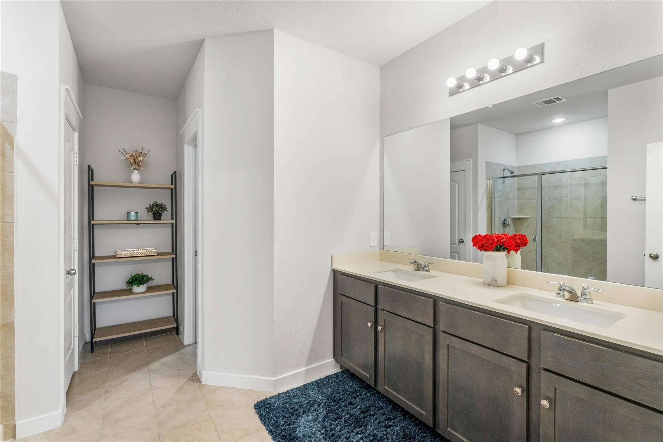 Double vanity featuring integrated sinks, light-toned countertops, and ample storage cabinetry