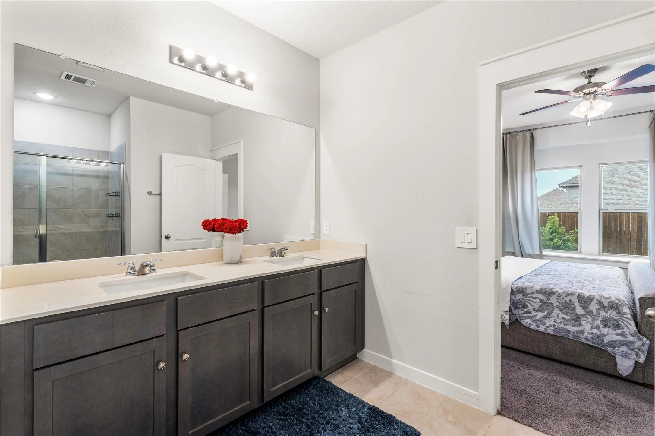 Double vanity with dark wood-finish cabinetry and light countertops