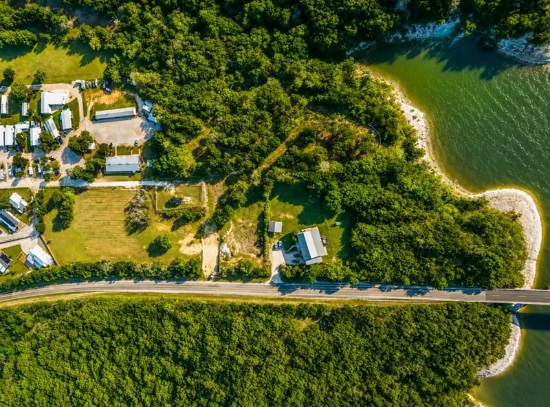Expansive acreage featuring significant waterfront access, a substantial road frontage, and a mix of developed and undeveloped land