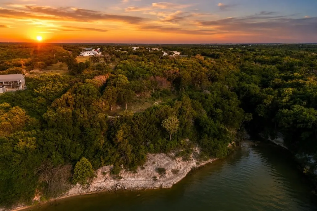 Expansive land parcel featuring dense tree cover and direct waterfront access