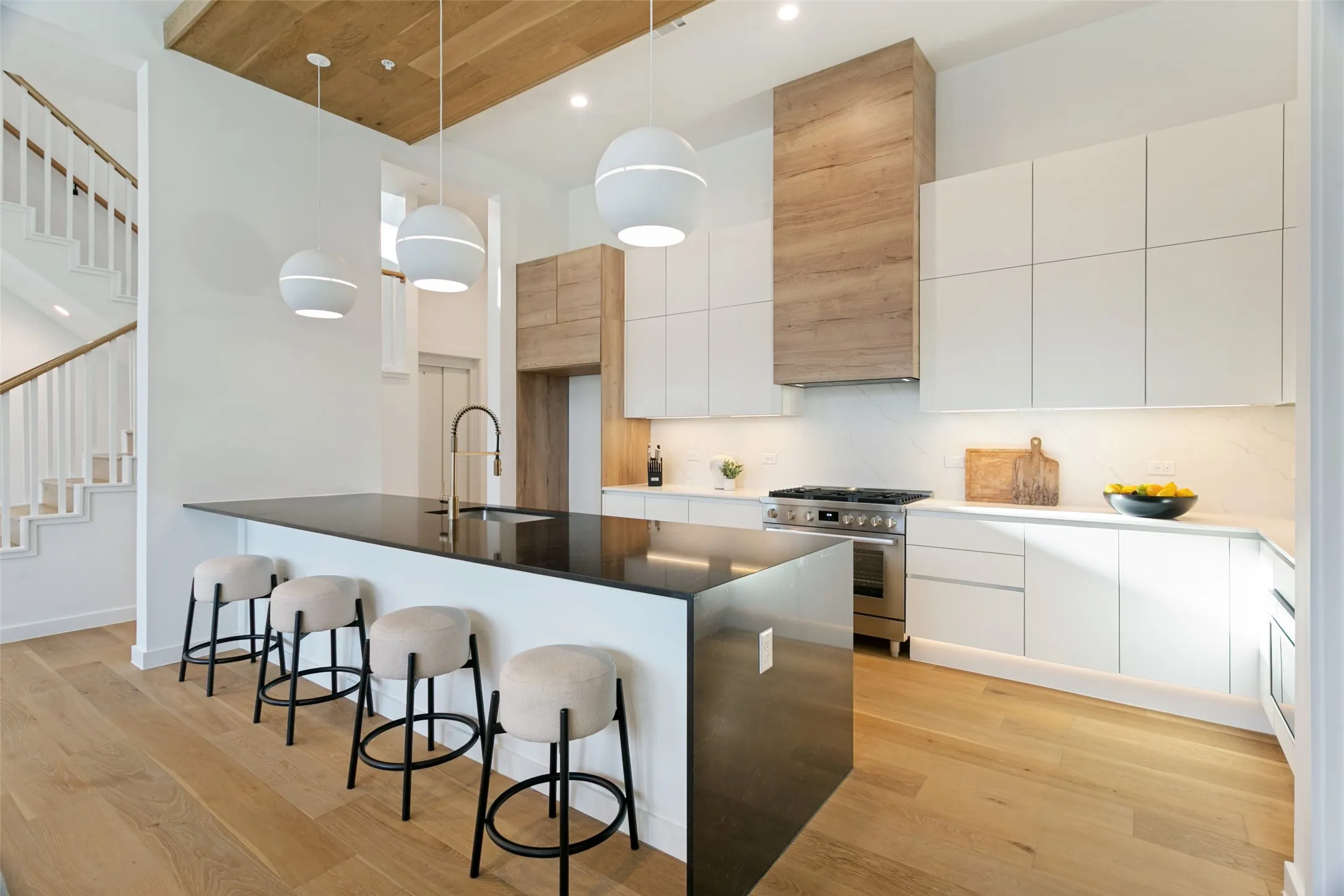 Gourmet kitchen with soft-close custom cabinetry, waterfall-edge quartz, Bosch appliances, white oak wood floors and wood finishes throughout.