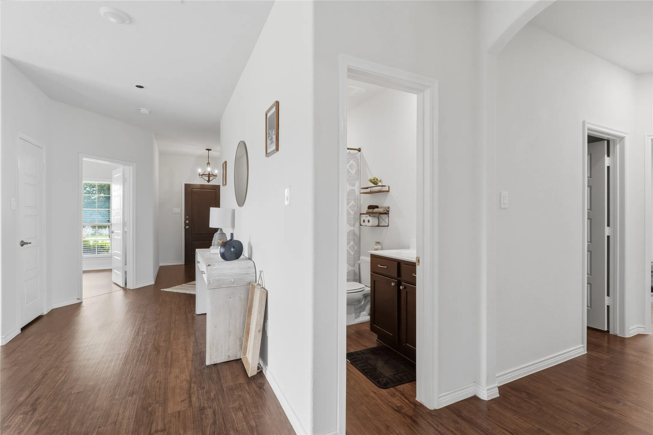 Entryway featuring wood-finish flooring, white trim, and a contemporary chandelier