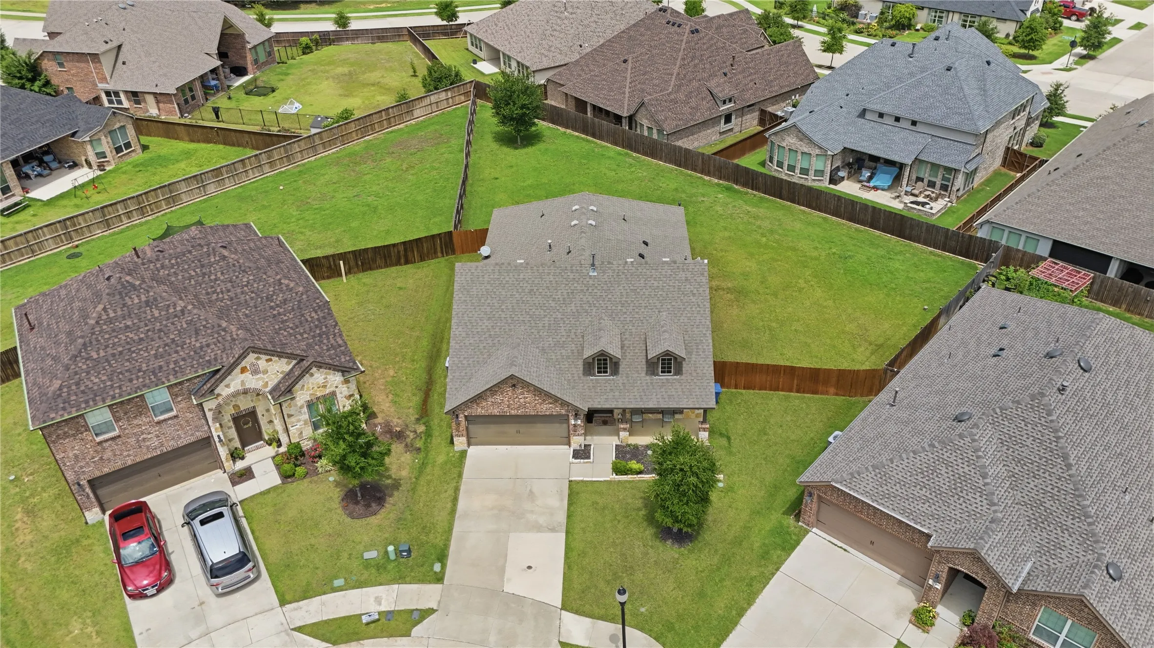 Two-story residence featuring a brick and stone facade, a two-car garage, and a covered front entry