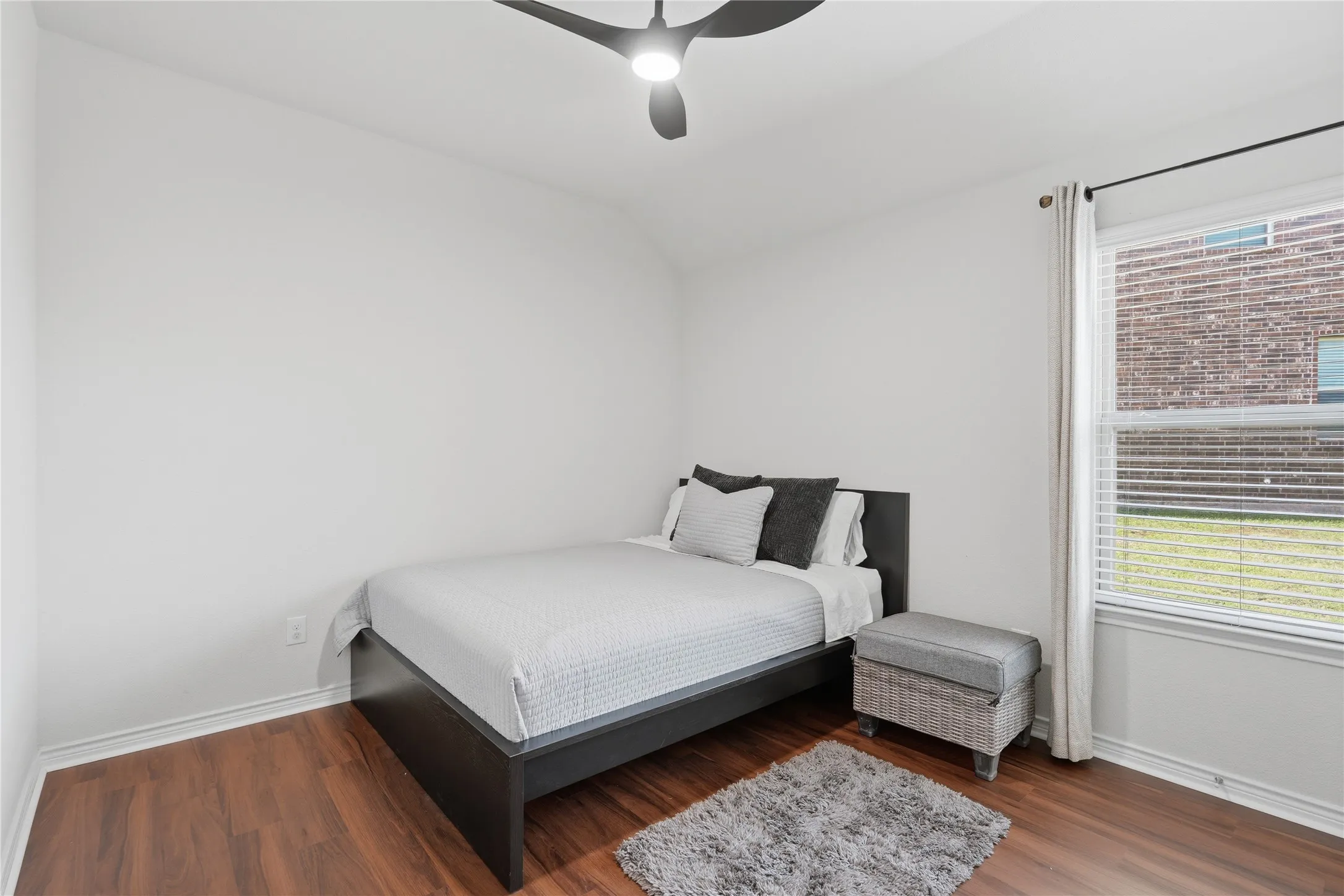 Bedroom featuring wood-finish flooring, a window with blinds and drapes, white walls, and a modern ceiling fan