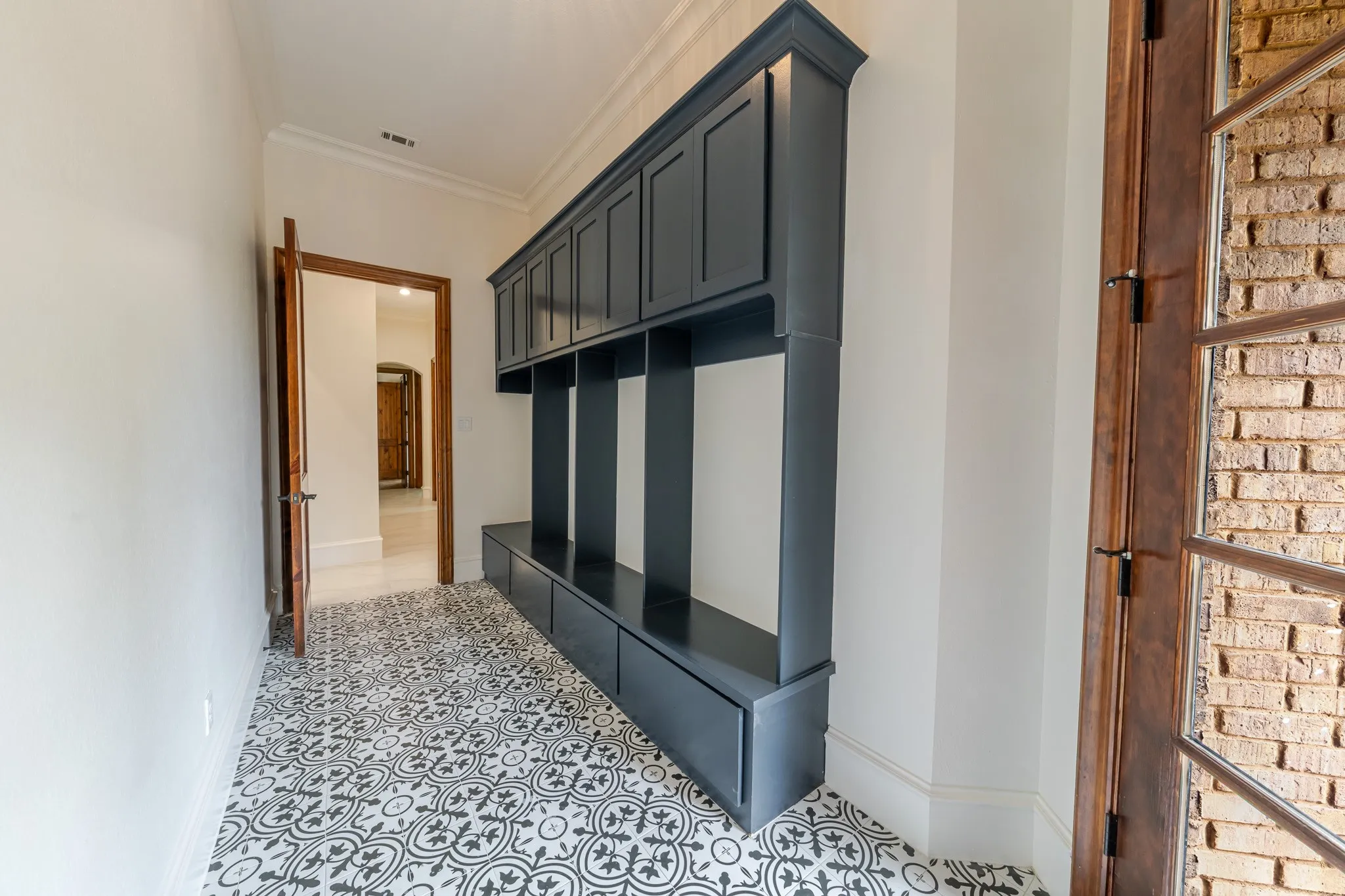 Entryway featuring patterned tile flooring and a built-in storage unit with cabinetry