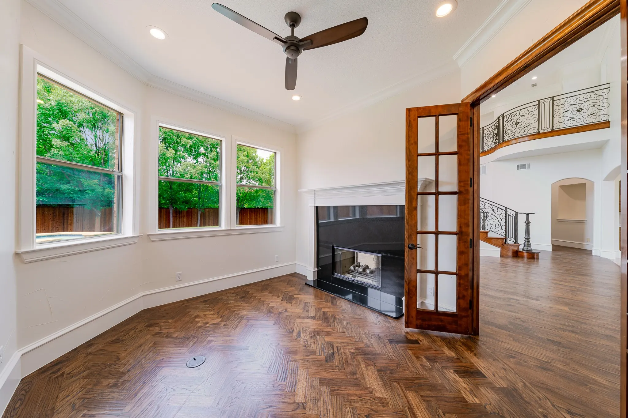 Study w hearing bone custom hardwood flooring & pass thru gas log fireplace & natural light.