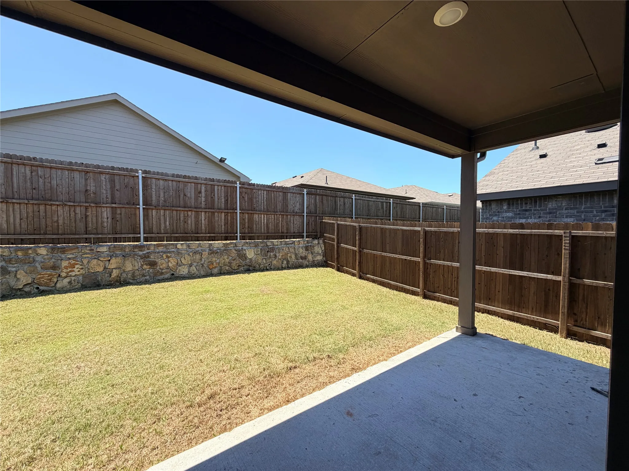 Covered patio with recessed lighting, concrete flooring, and an expansive lawn