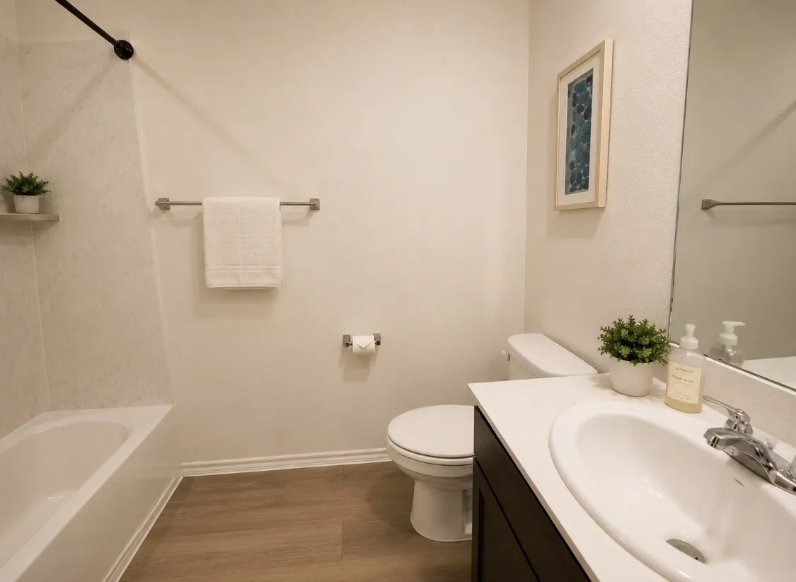 Bathroom featuring a built-in tub with a white surround and a black shower fixture