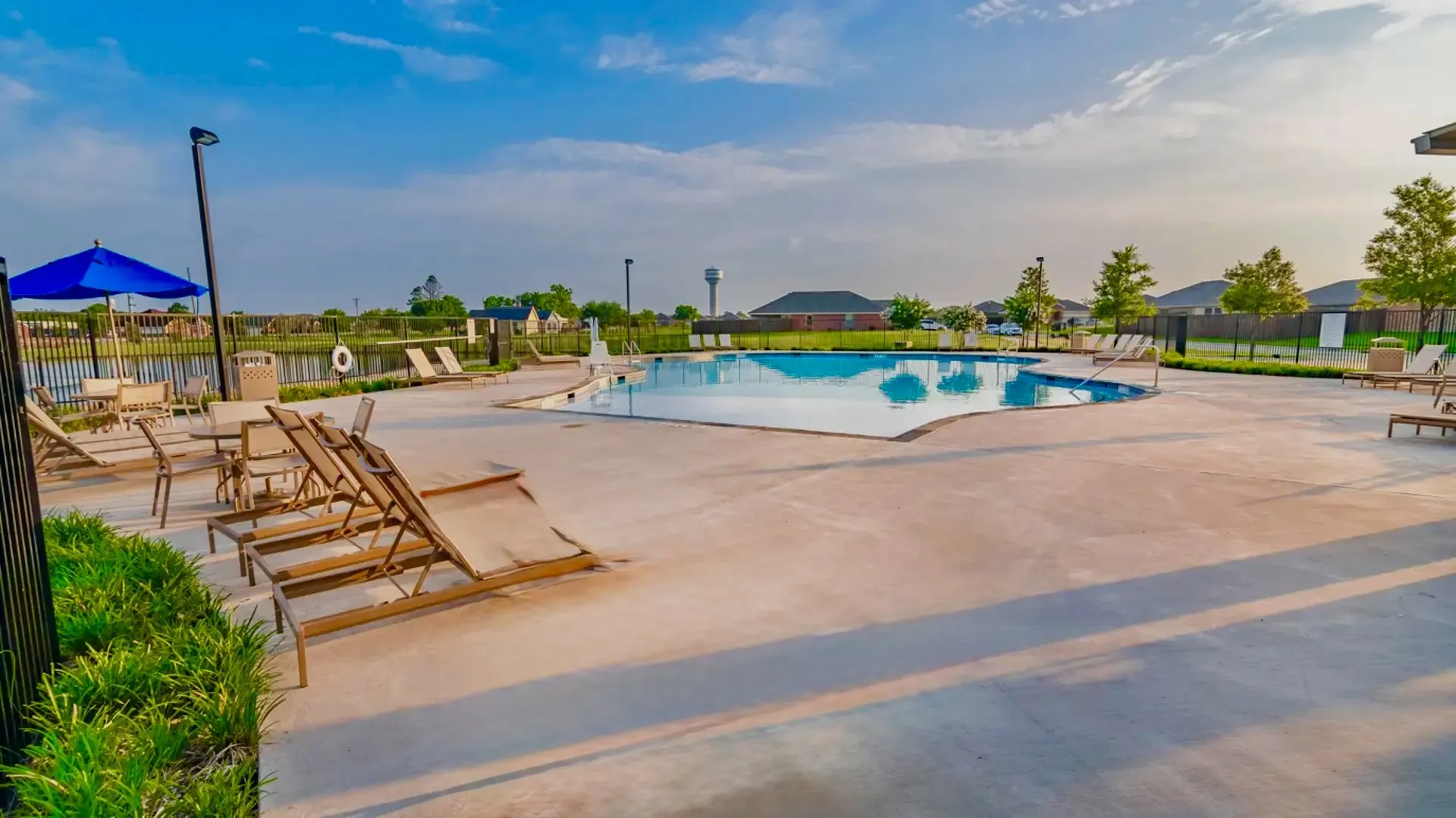 Community swimming pool featuring a freeform design and ample surrounding concrete decking