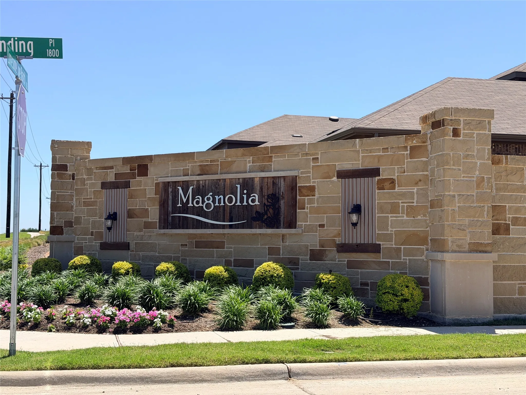 Stone monument sign featuring a central "Magnolia" wood-finish panel