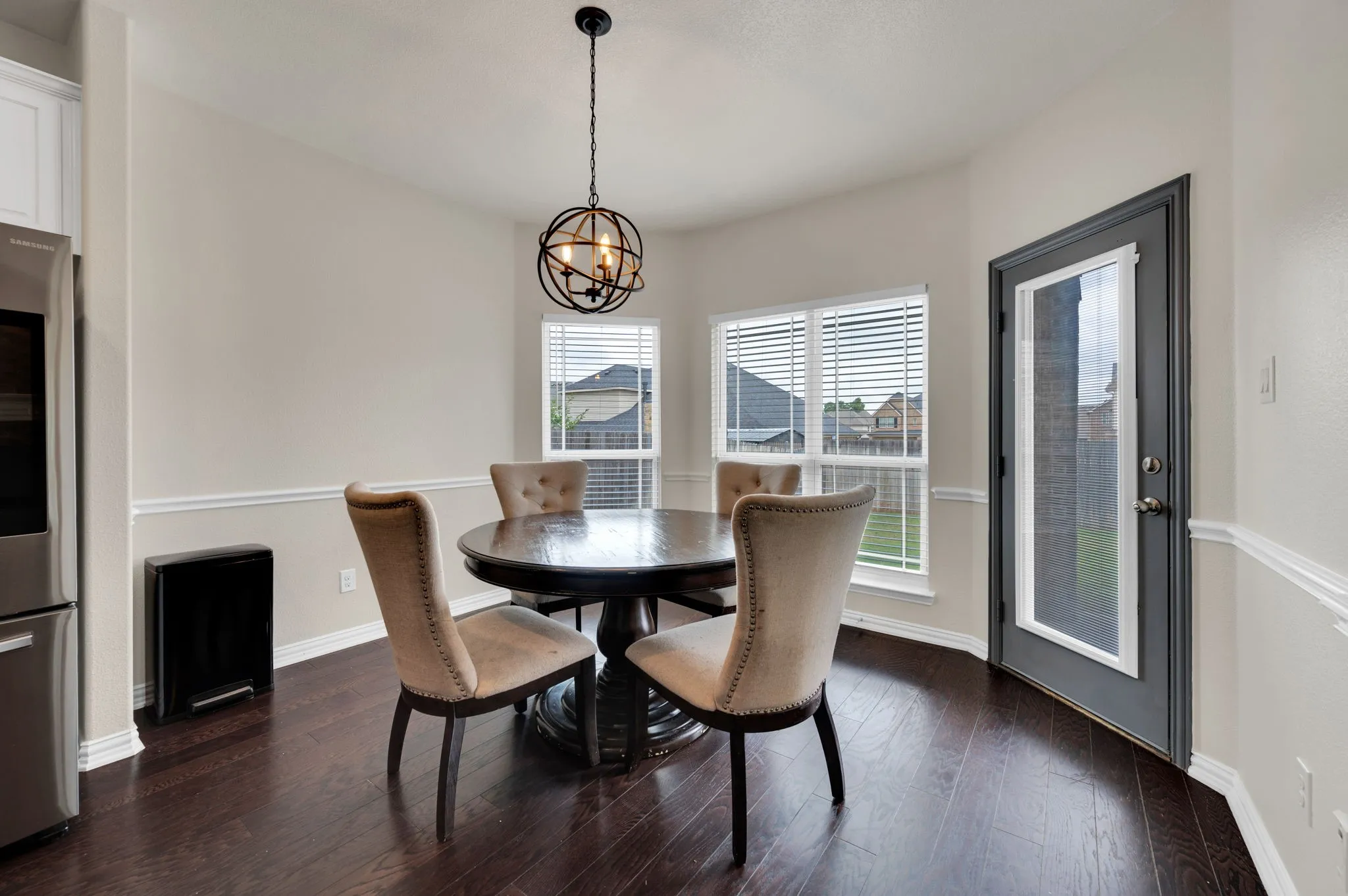 Dining area featuring wood-finish flooring and a contemporary spherical chandelier