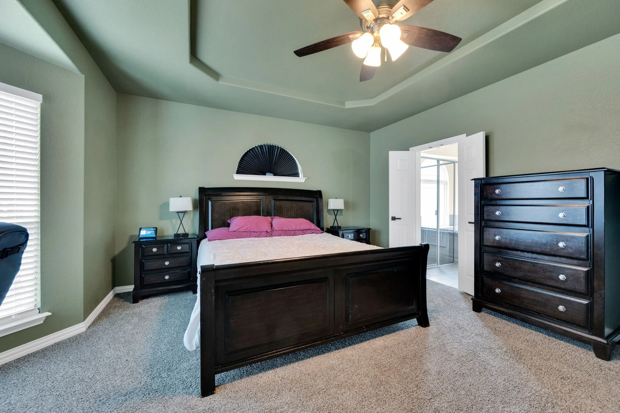 Spacious room with tray ceiling, ceiling fan, and carpeted flooring
