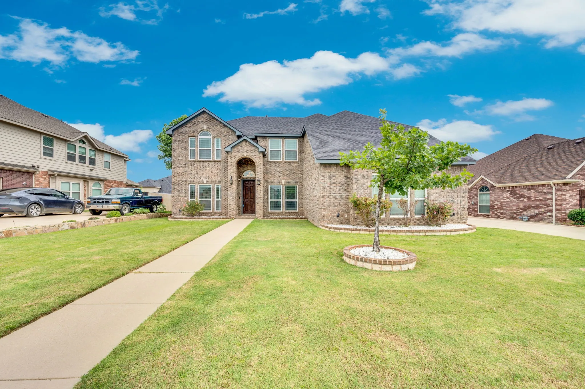 Two-story brick facade residence with arched entry and dark wood door