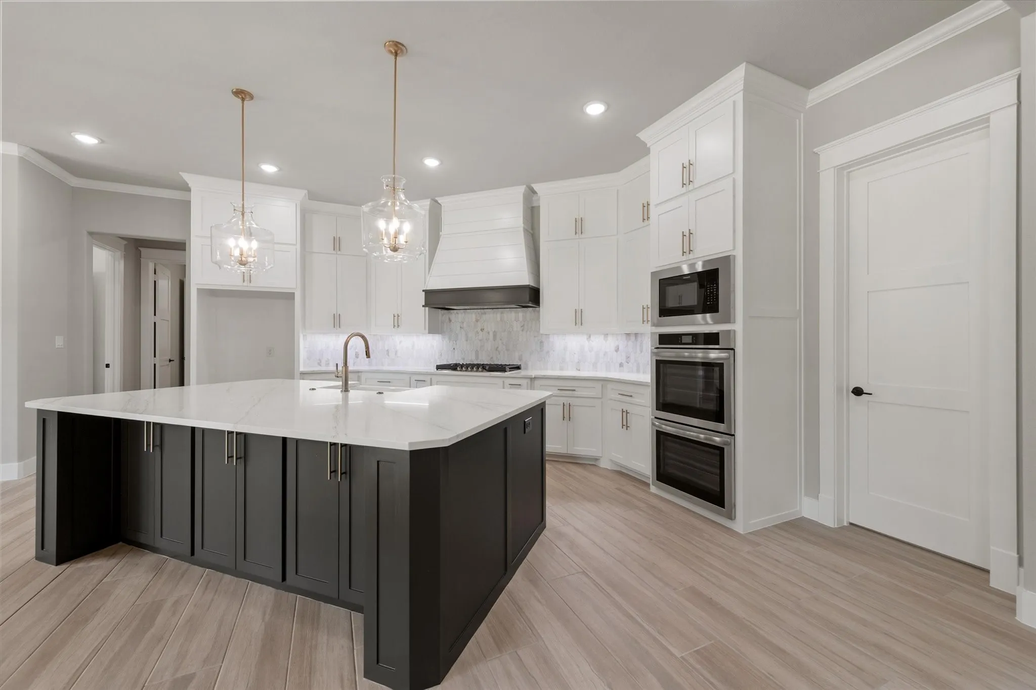 Spacious kitchen featuring a large central island with dark cabinetry and a light countertop