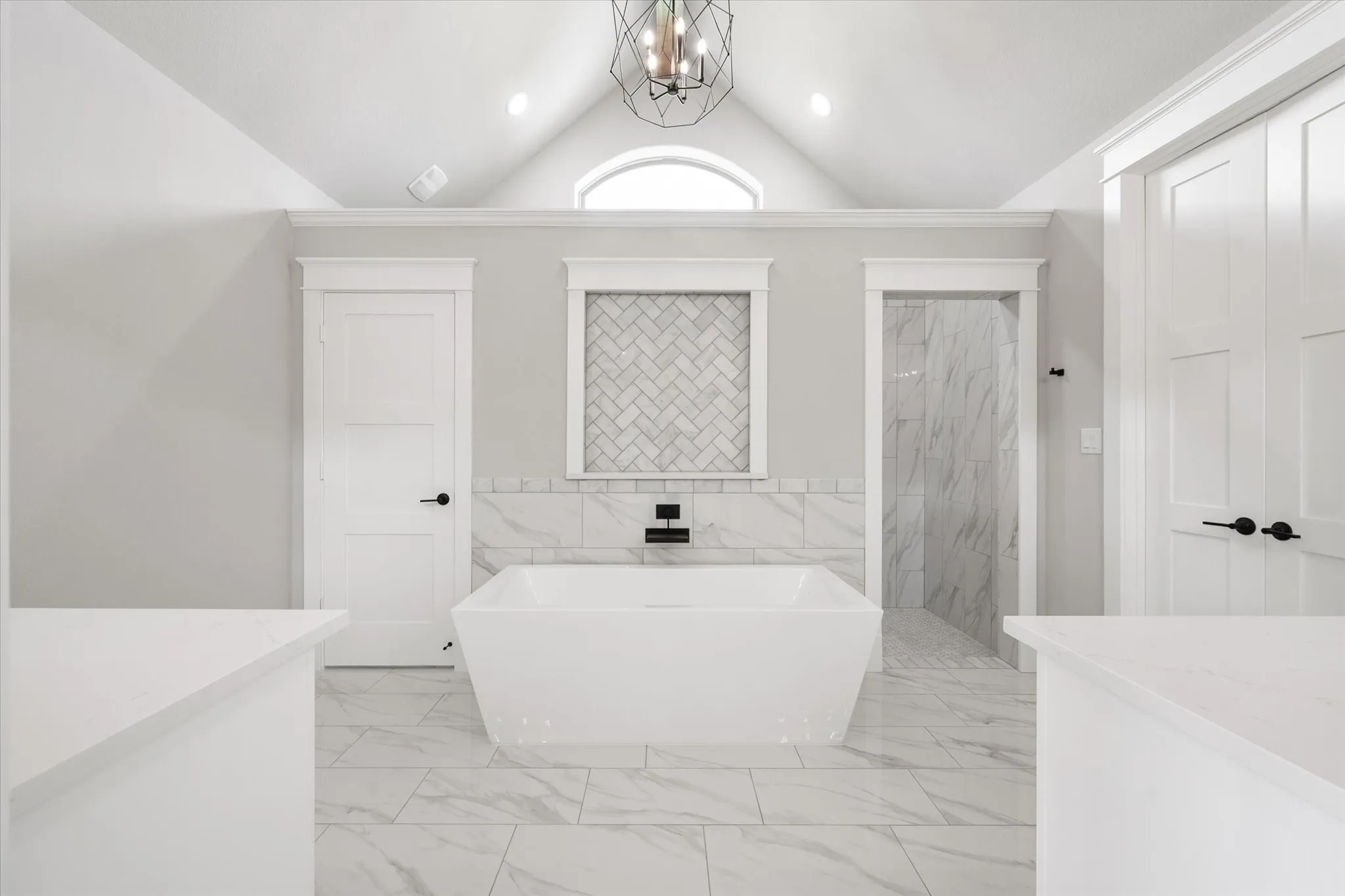 Freestanding soaking tub with a wall-mounted matte black faucet